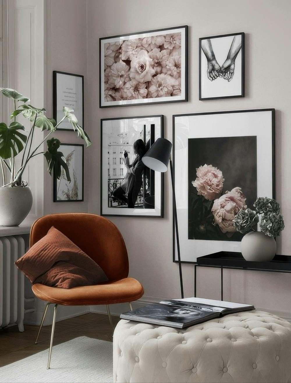 En tavelvägg med blommotiv av pioner i rosa och beige, samt handmotiv och en kvinna vid ett fönster i svartvitt.