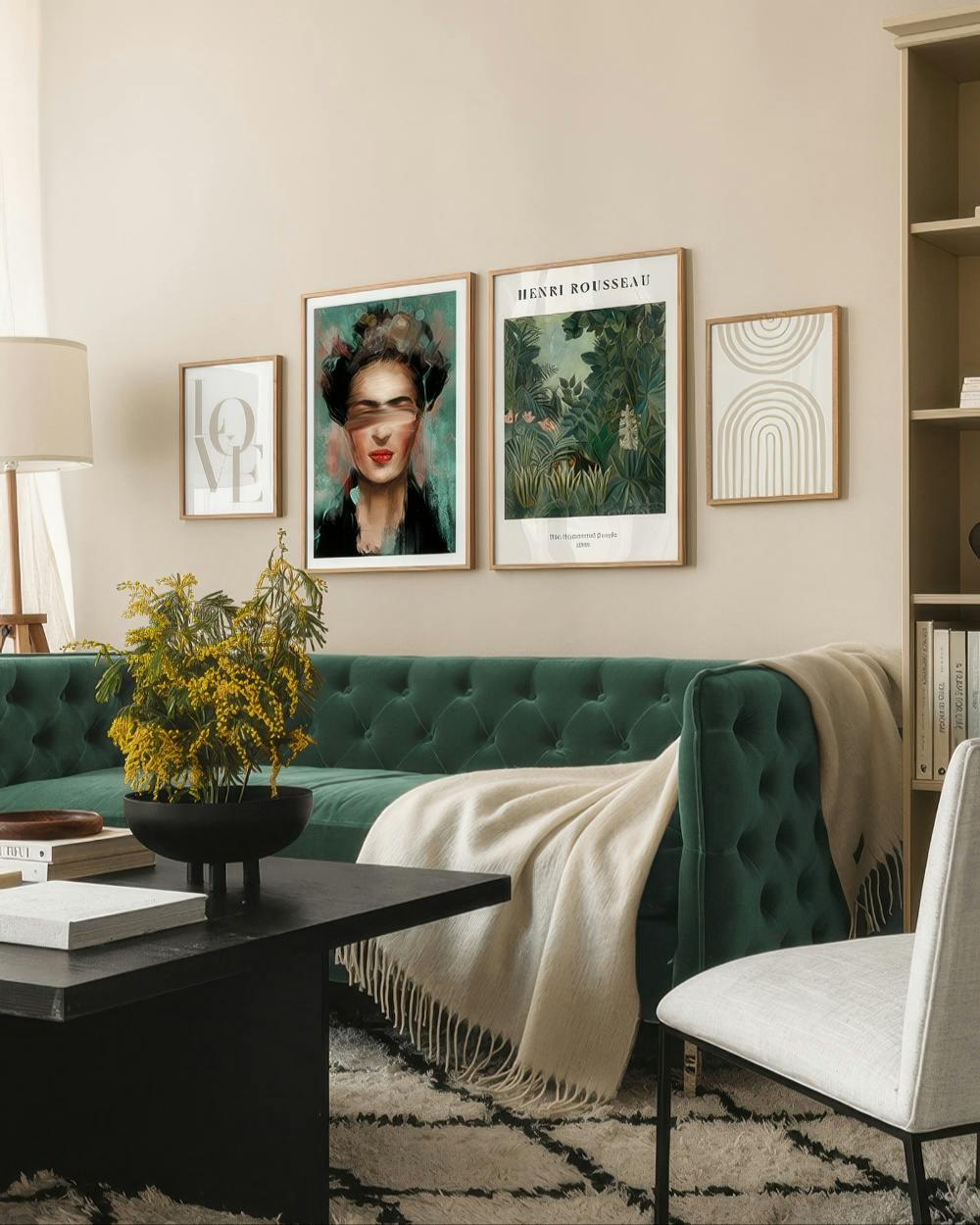 A living room scene with a poster pack of four framed prints above a green velvet sofa, featuring abstract art and a jungle land