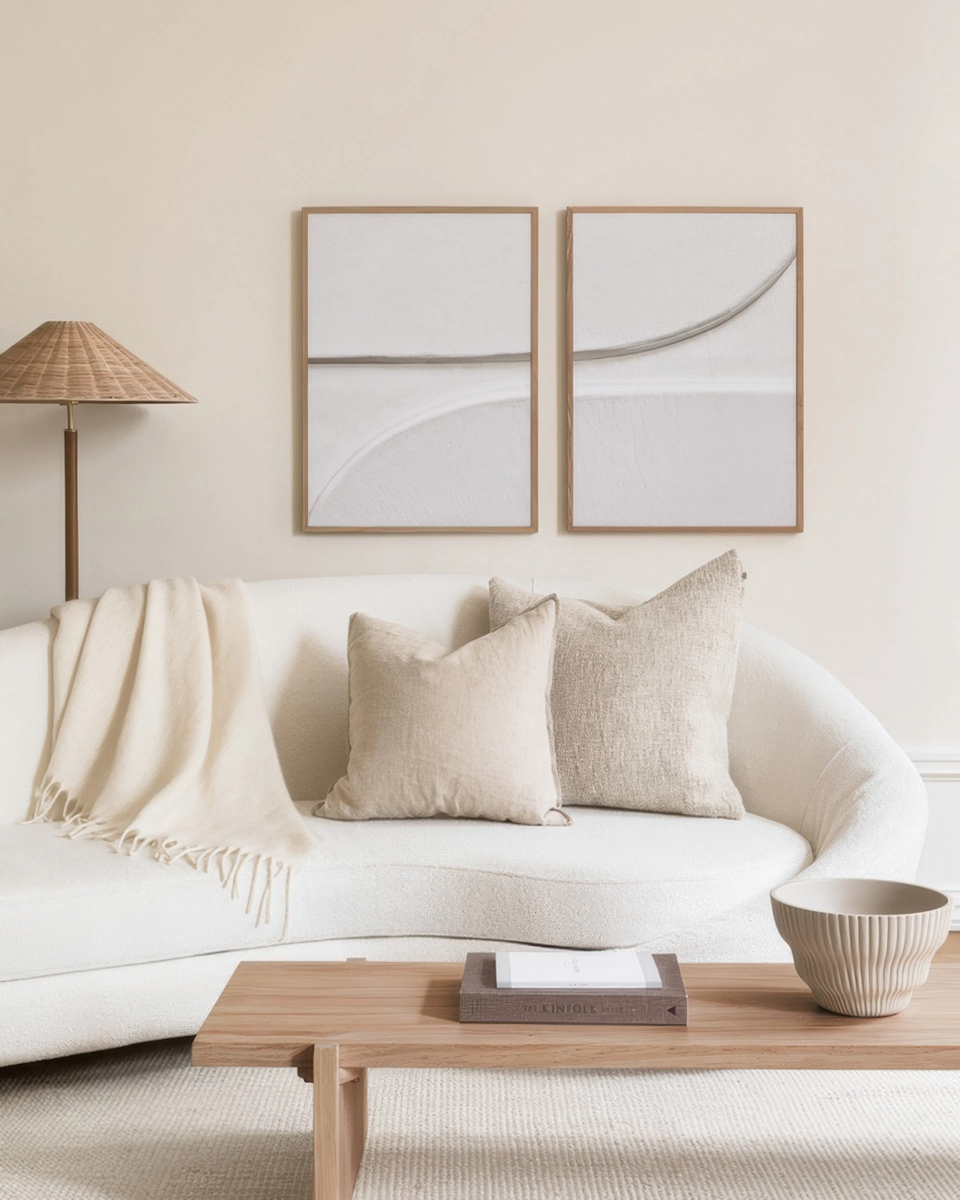A poster pack featuring two framed abstract prints with subtle grey lines and textured white backgrounds, displayed above a sofa