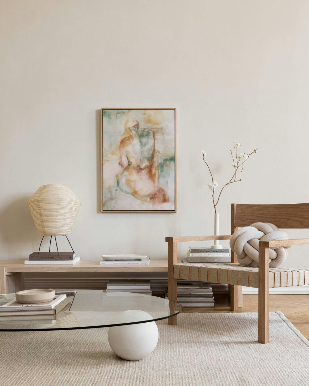 Leinwandbild mit abstrakten Formen in Beige, Braun und Grün, in einem modern eingerichteten Wohnzimmer.