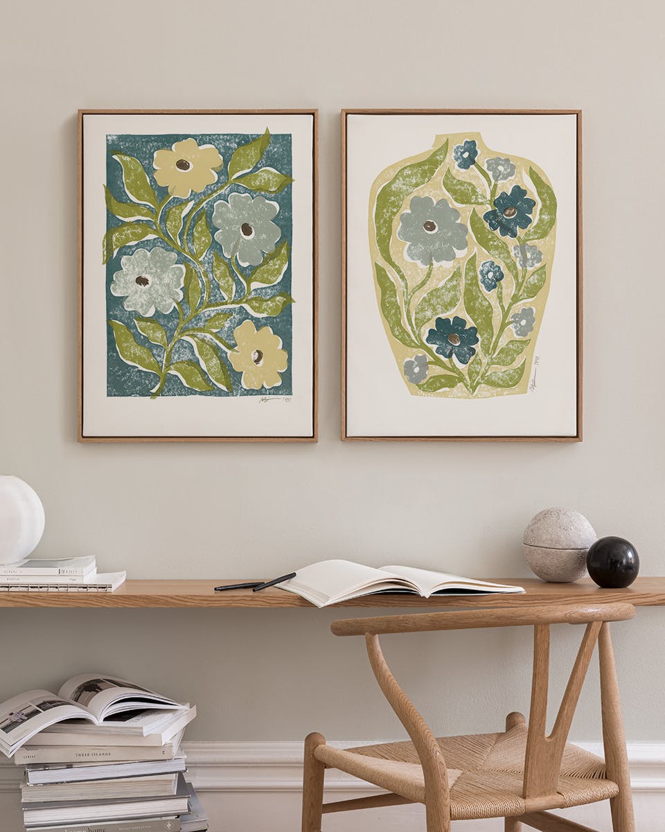 A poster pack featuring two botanical prints, one with light and dark blue flowers on a teal background, and another with flower