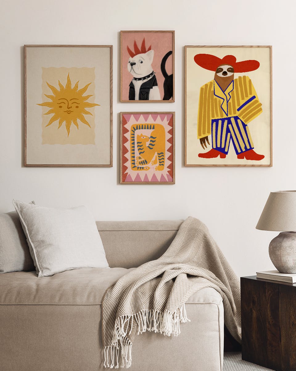 Pacchetti di poster: quattro stampe artistiche su una parete bianca sopra un divano beige con cuscini e coperta, e un tavolino c