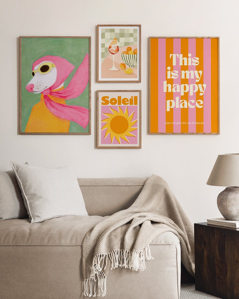 En plakatpakke med fem farverige plakater på en billedvæg over en lys sofa i en stue.