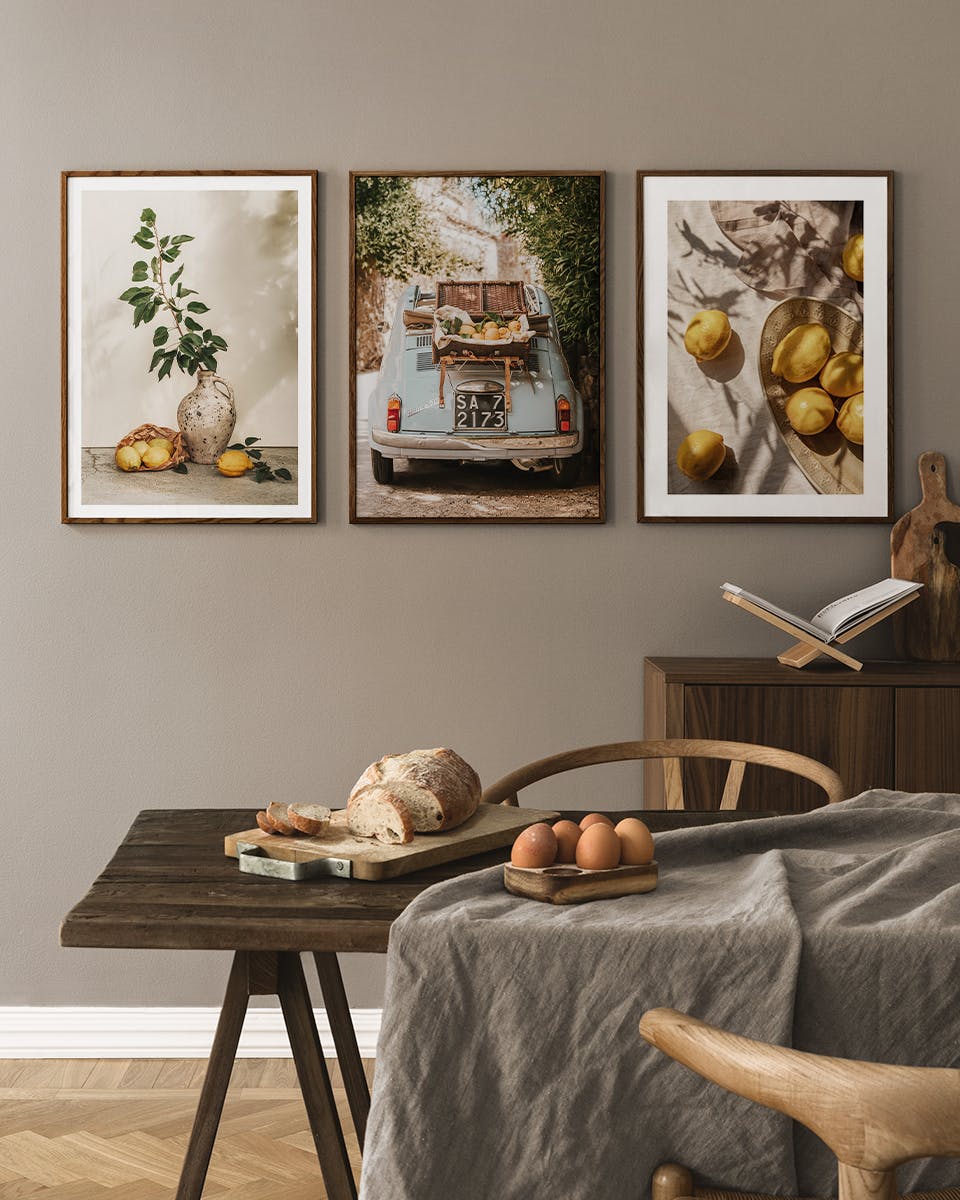 Ett posterpaket med tre tavlor hängandes på en vägg ovanför ett matbord med bröd och ägg.