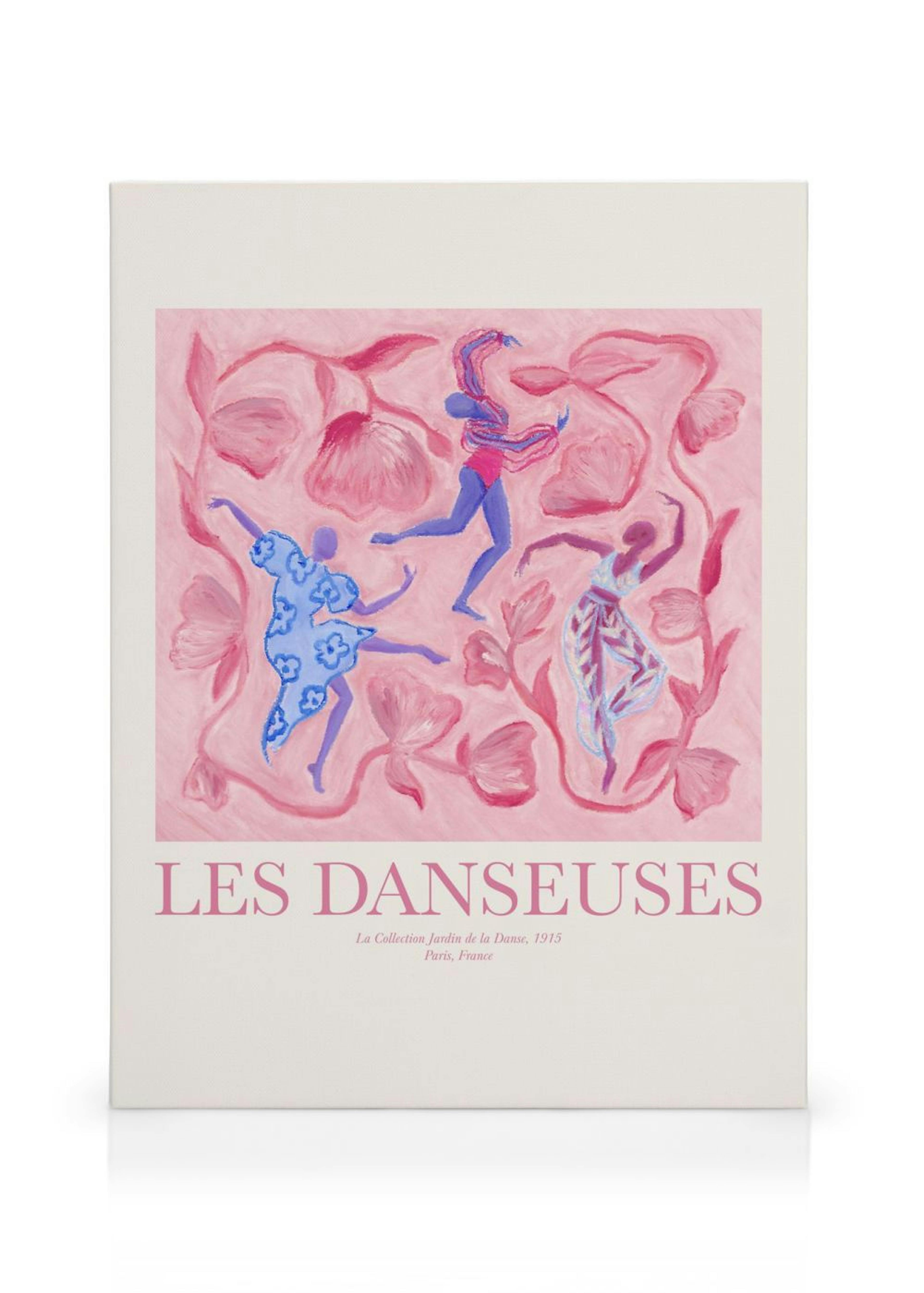 Leinwandbild mit drei tanzenden Frauen in blauen und rosa Tönen auf rosa Hintergrund, umgeben von floralen Elementen.