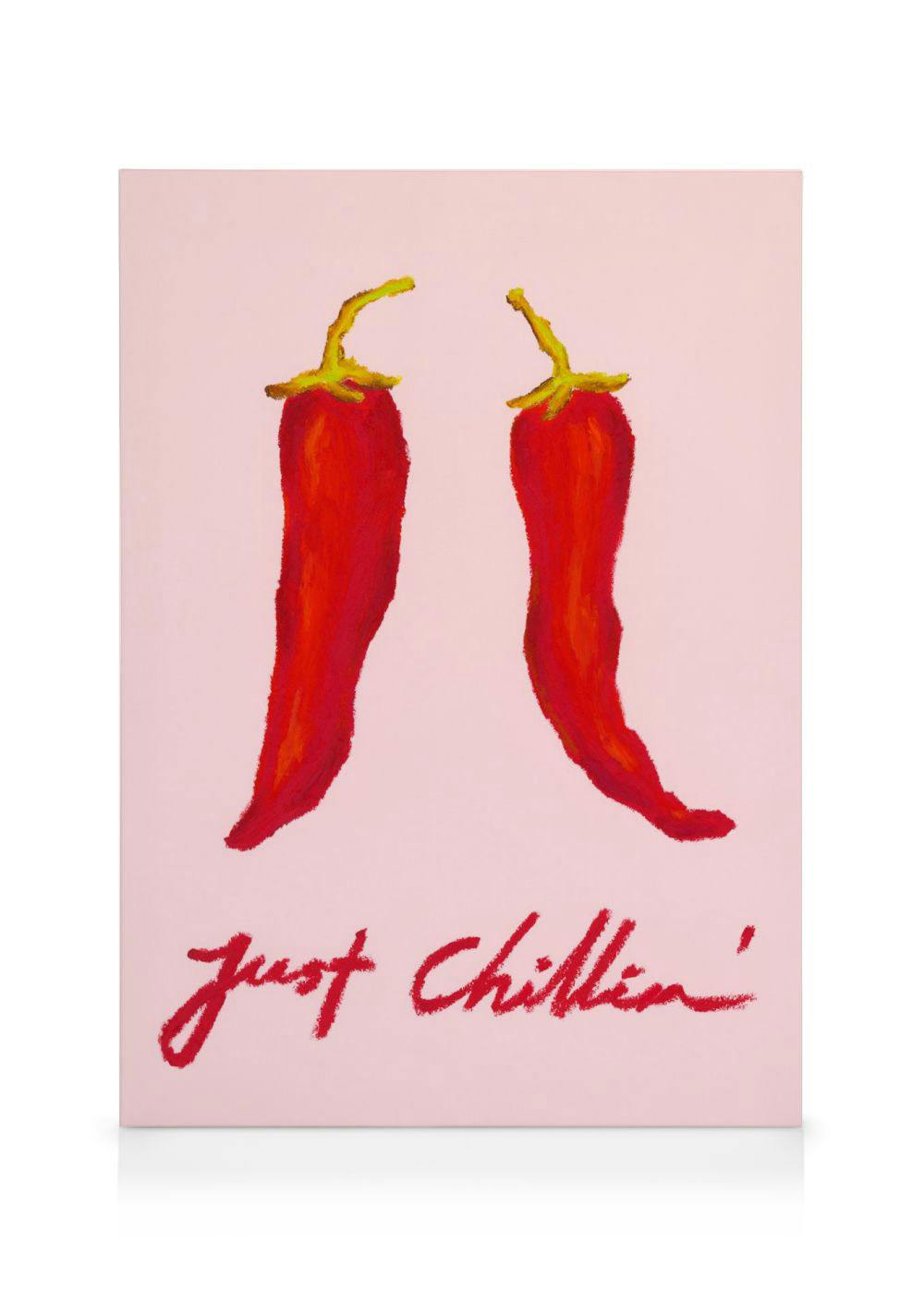 A canvas print with two red chili peppers and the text Just Chillin on a pink background.