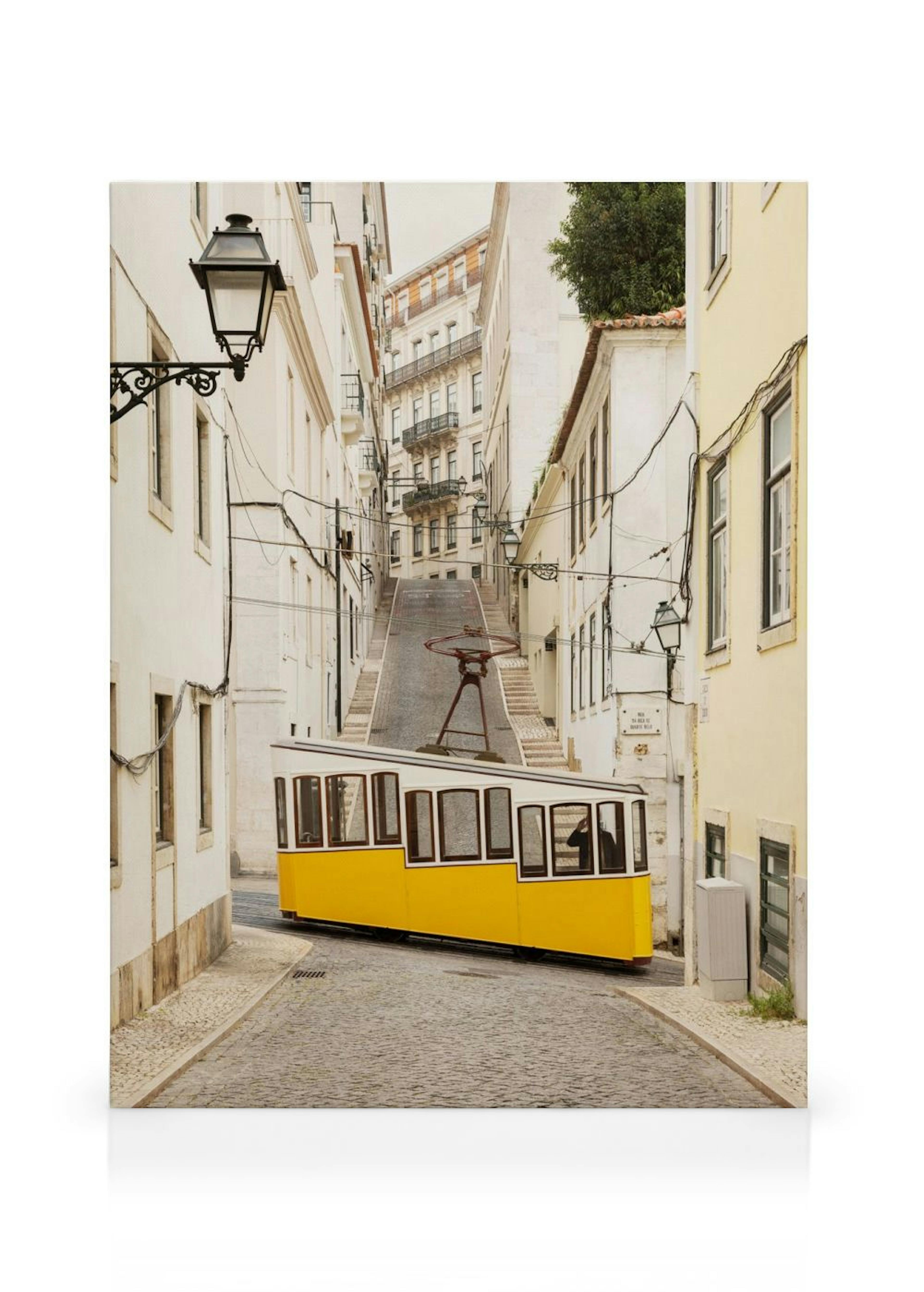 Leinwandbild mit einer gelben Straßenbahn in einer steilen, gepflasterten Gasse Lissabons, umgeben von weißen Gebäuden.
