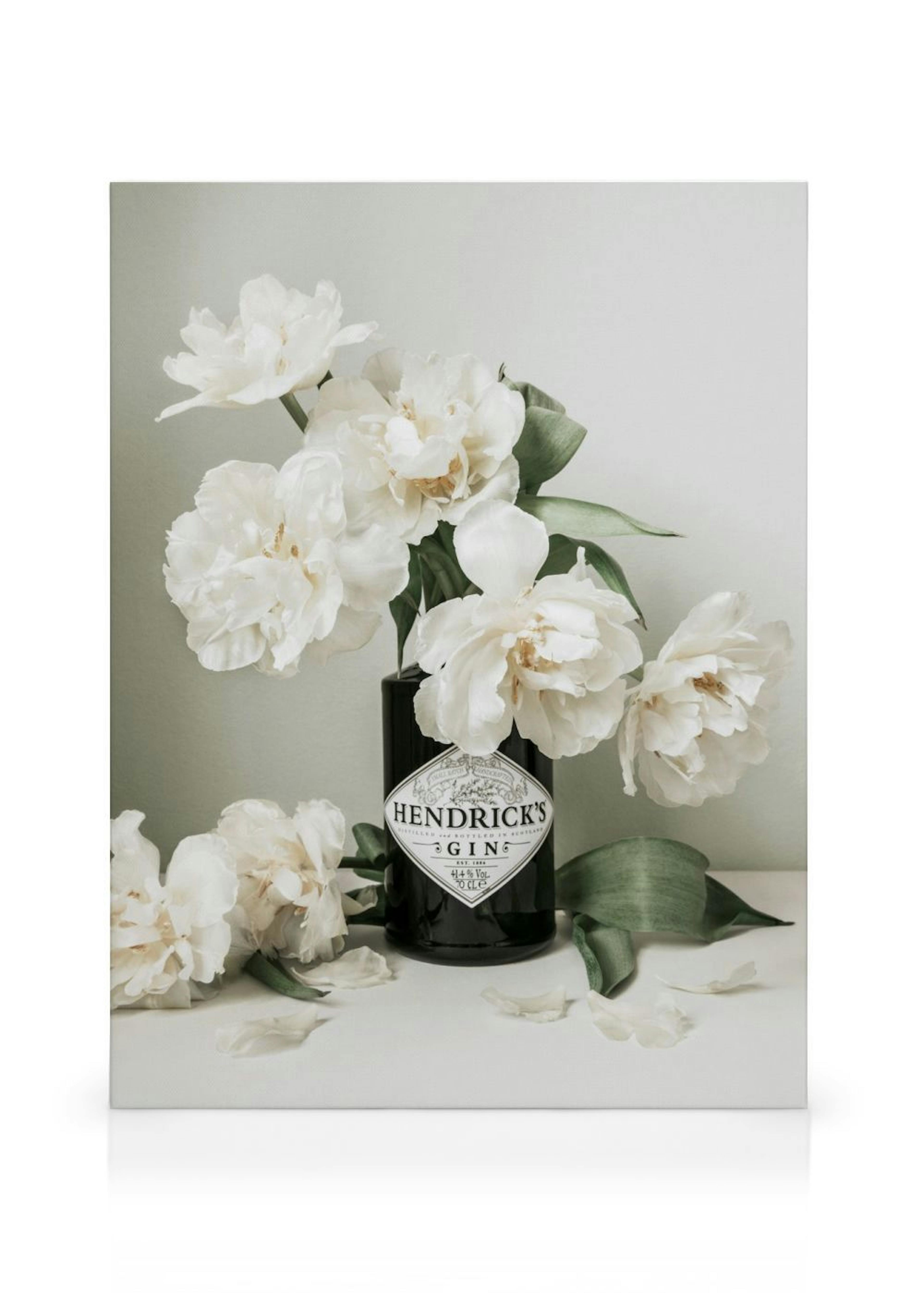 Leinwandbild mit weißem Pfingstrosenstrauß in einer schwarzen Hendricks Gin Flasche auf einem weißen Regal.