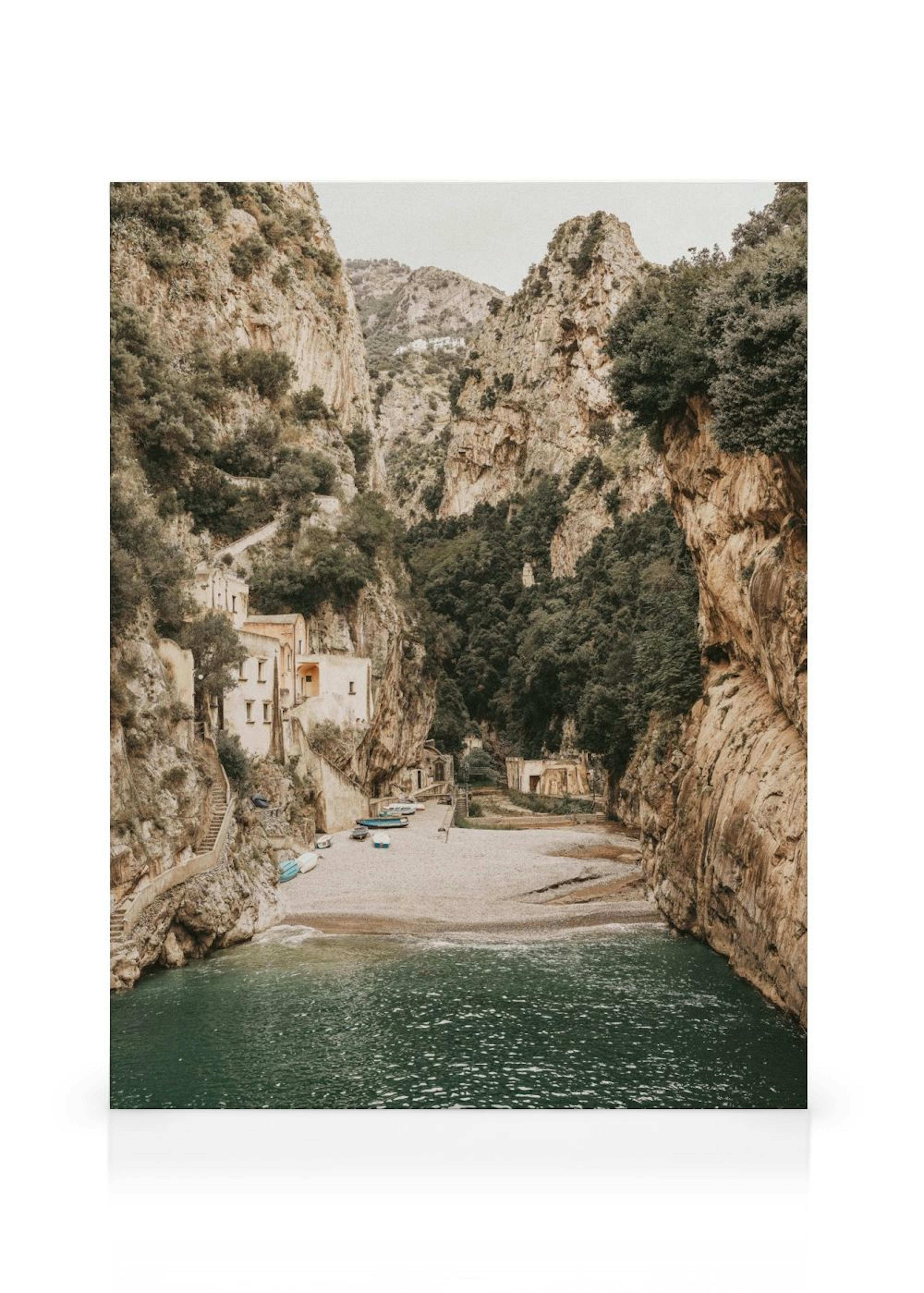 Leinwandbild einer Bucht zwischen hohen Felsen mit alten Häusern, Sandstrand und grüner See.