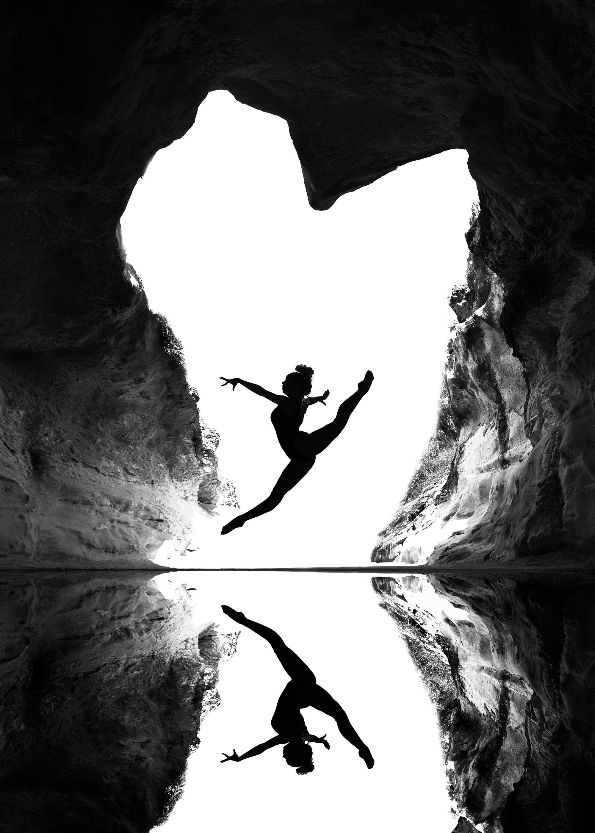 Zwart-wit poster van een danseres die in een hartvormige grot springt met reflectie