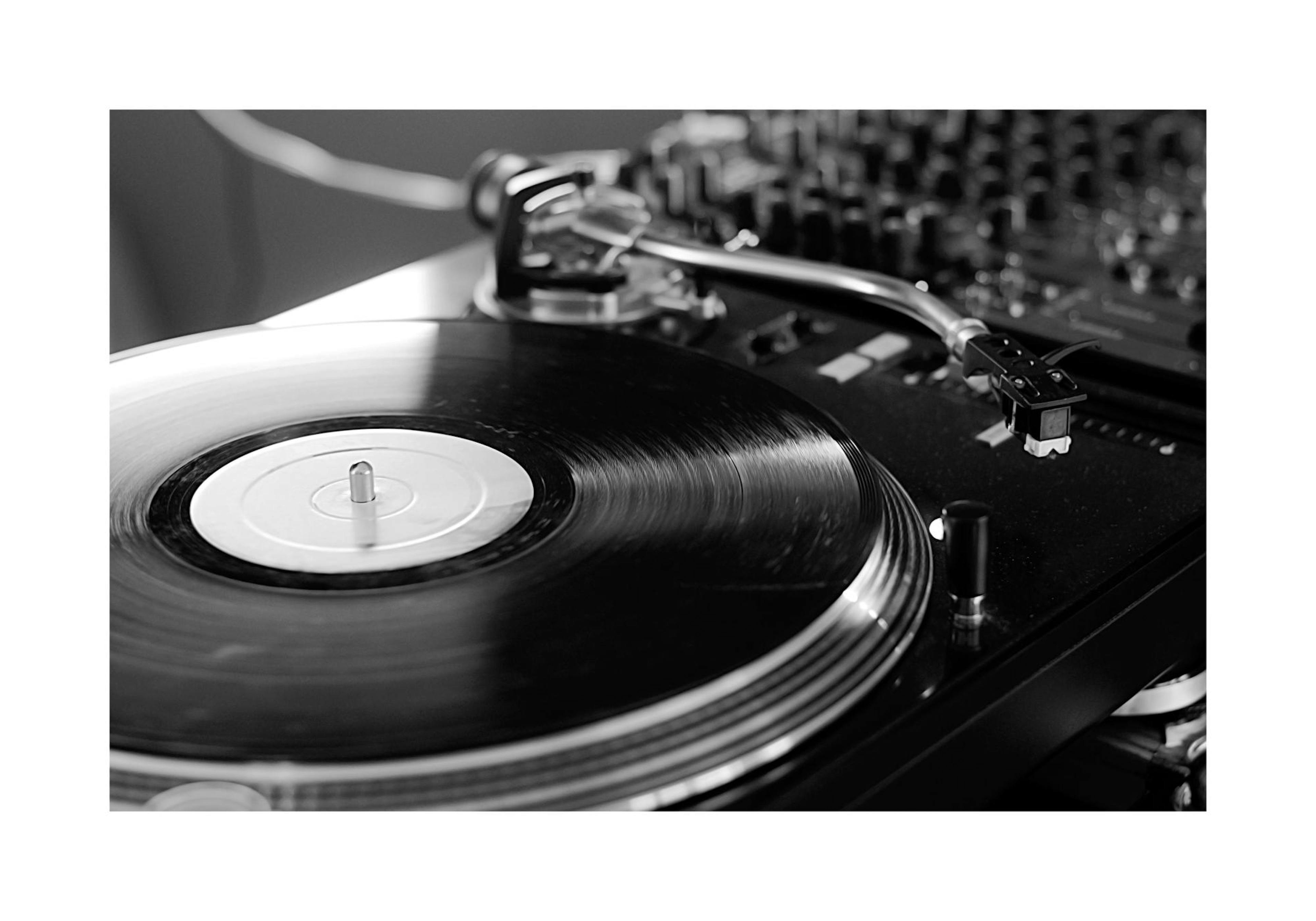 Schwarz-weißes Poster eines Plattenspielers mit Vinylplatte, Tonarm und Mischpult im Hintergrund.