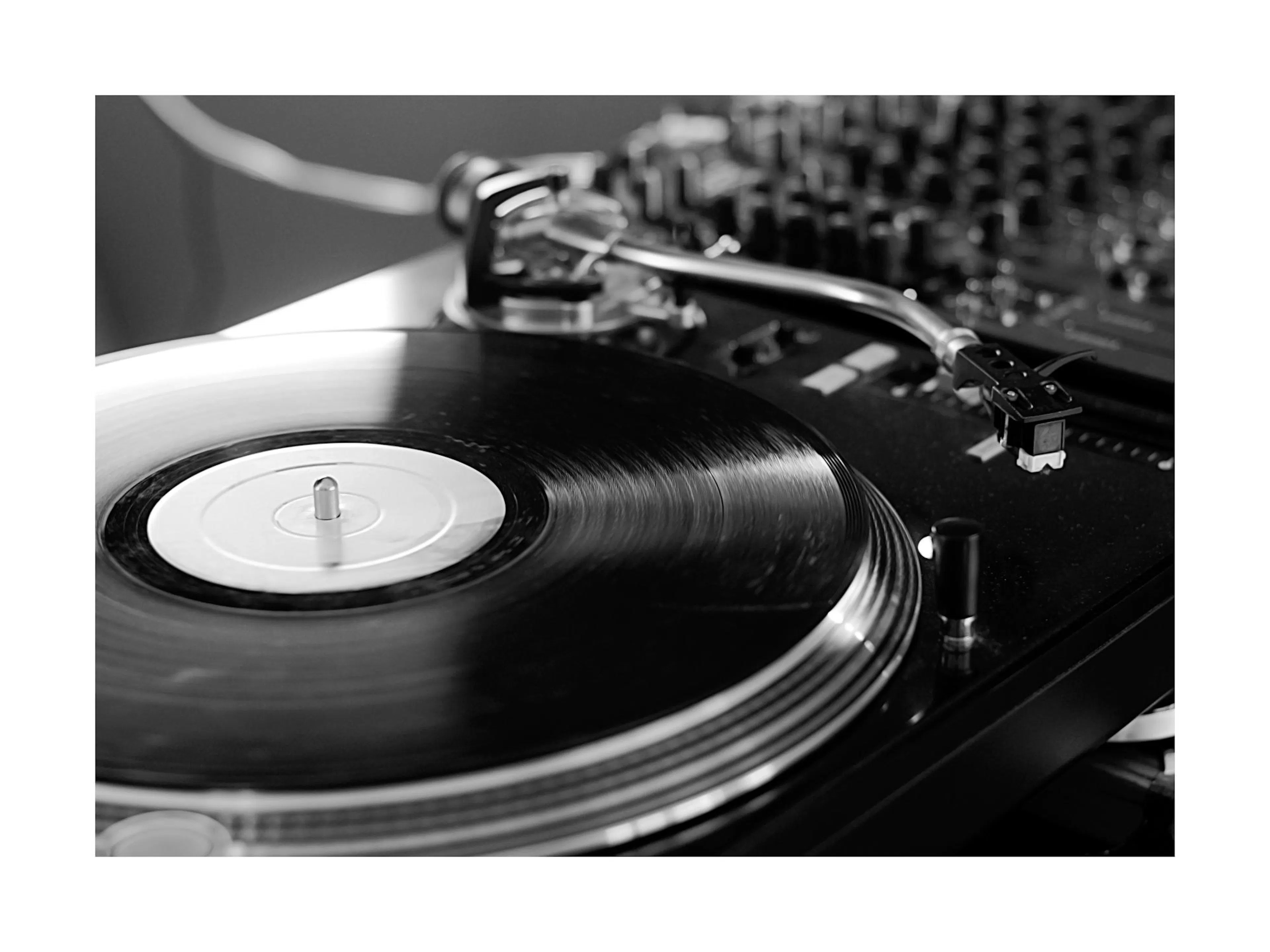 Affiche noir et blanc dune platine avec un vinyle, mettant en valeur lappareil et le disque, bordure blanche.