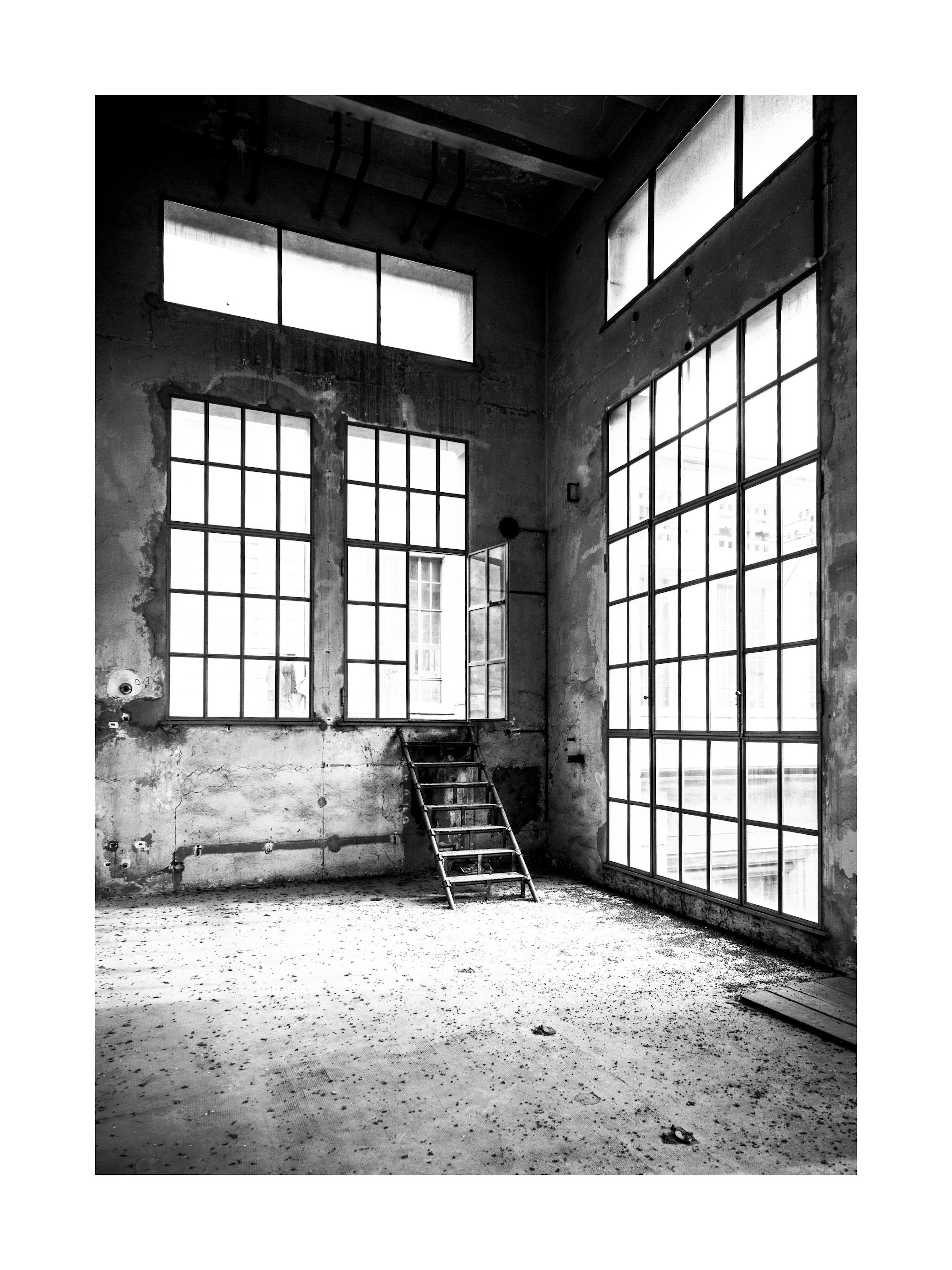 廃墟となった建物の白黒ポスター、大きな窓と階段がある部屋