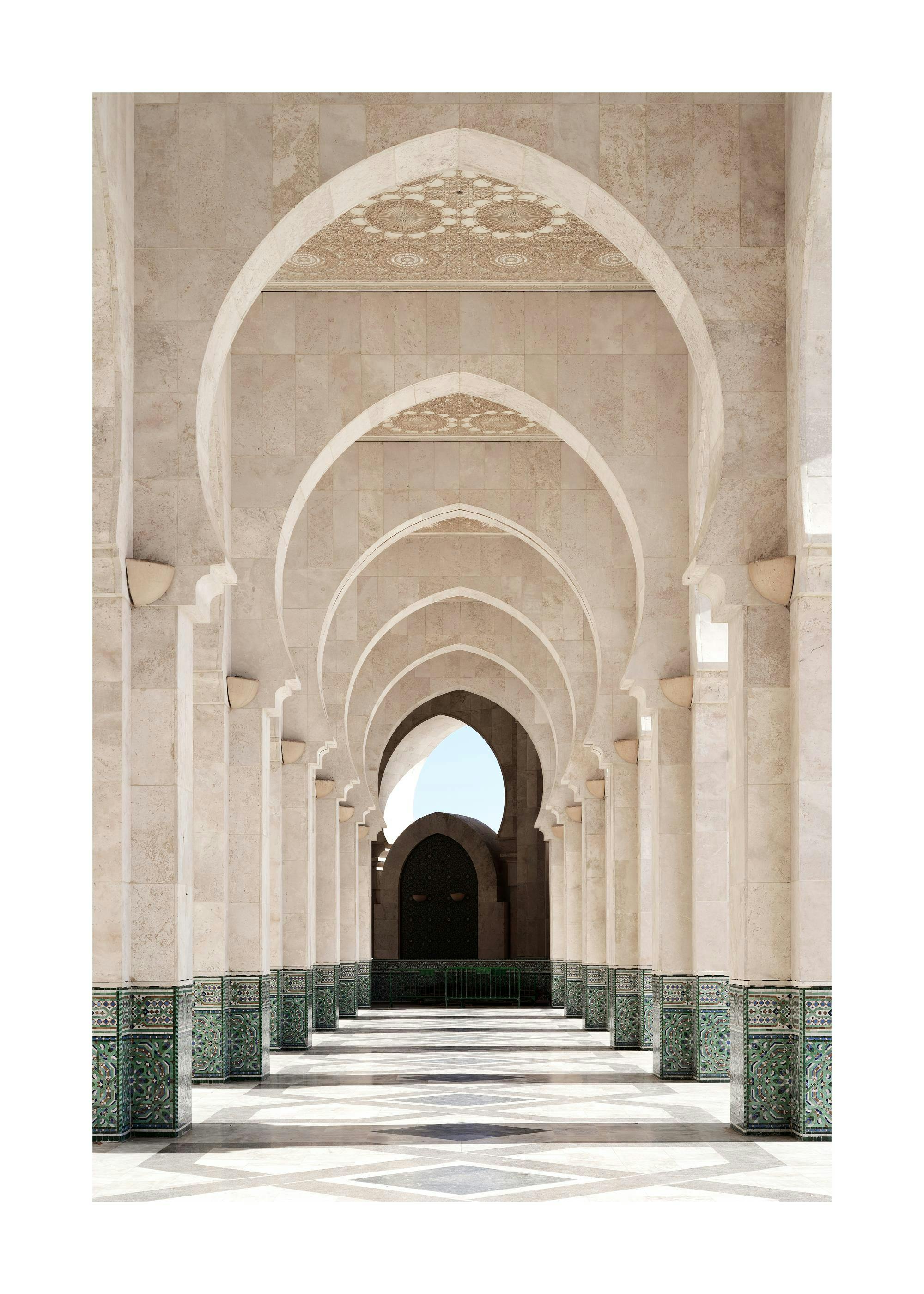 Morocco Arcade Print: arched hallway with light stone columns and green mosaic tiles, leading to a dark archway.