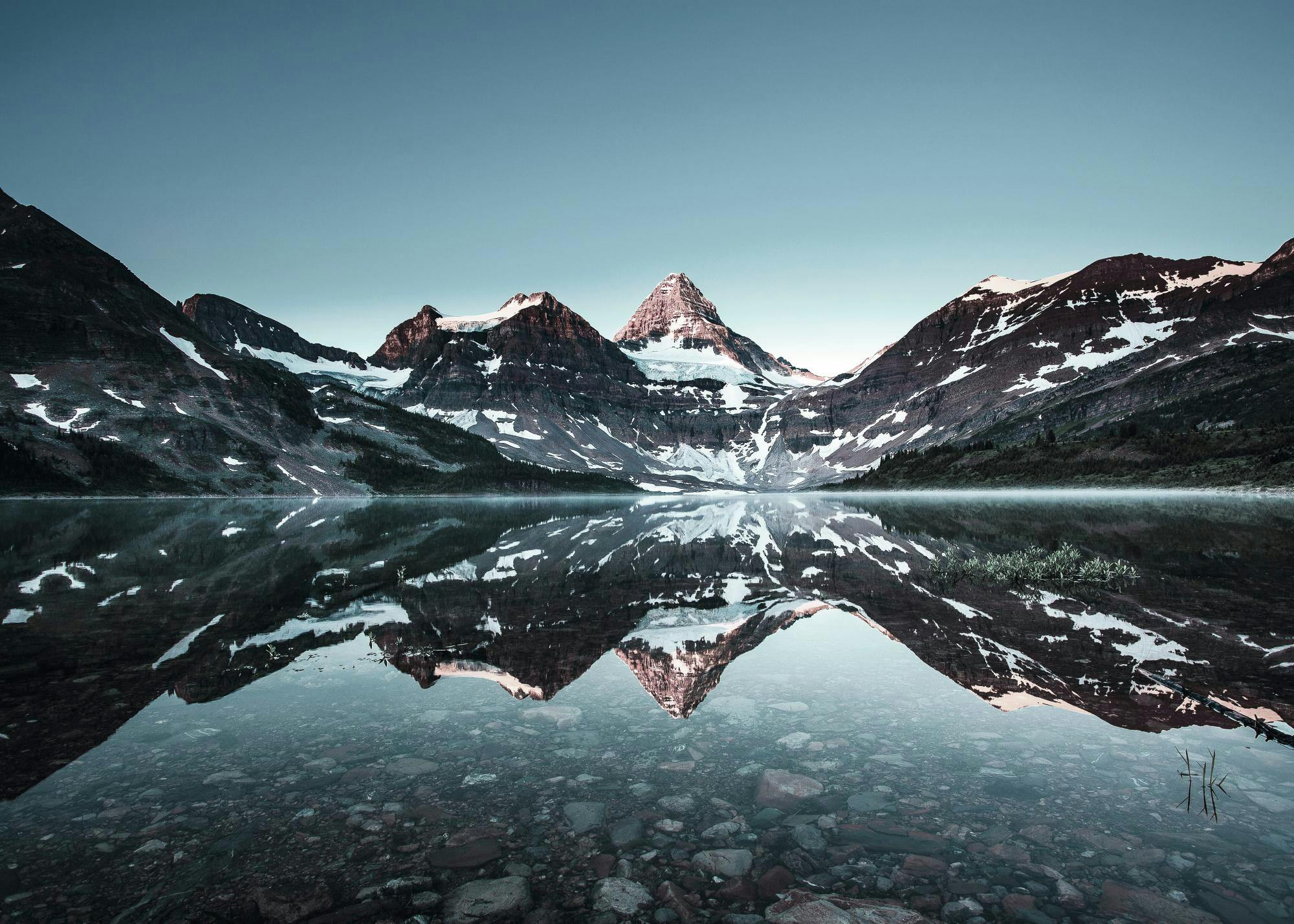 Affiche de paysage avec montagnes enneigées et leur reflet parfait dans leau dun lac rocheux