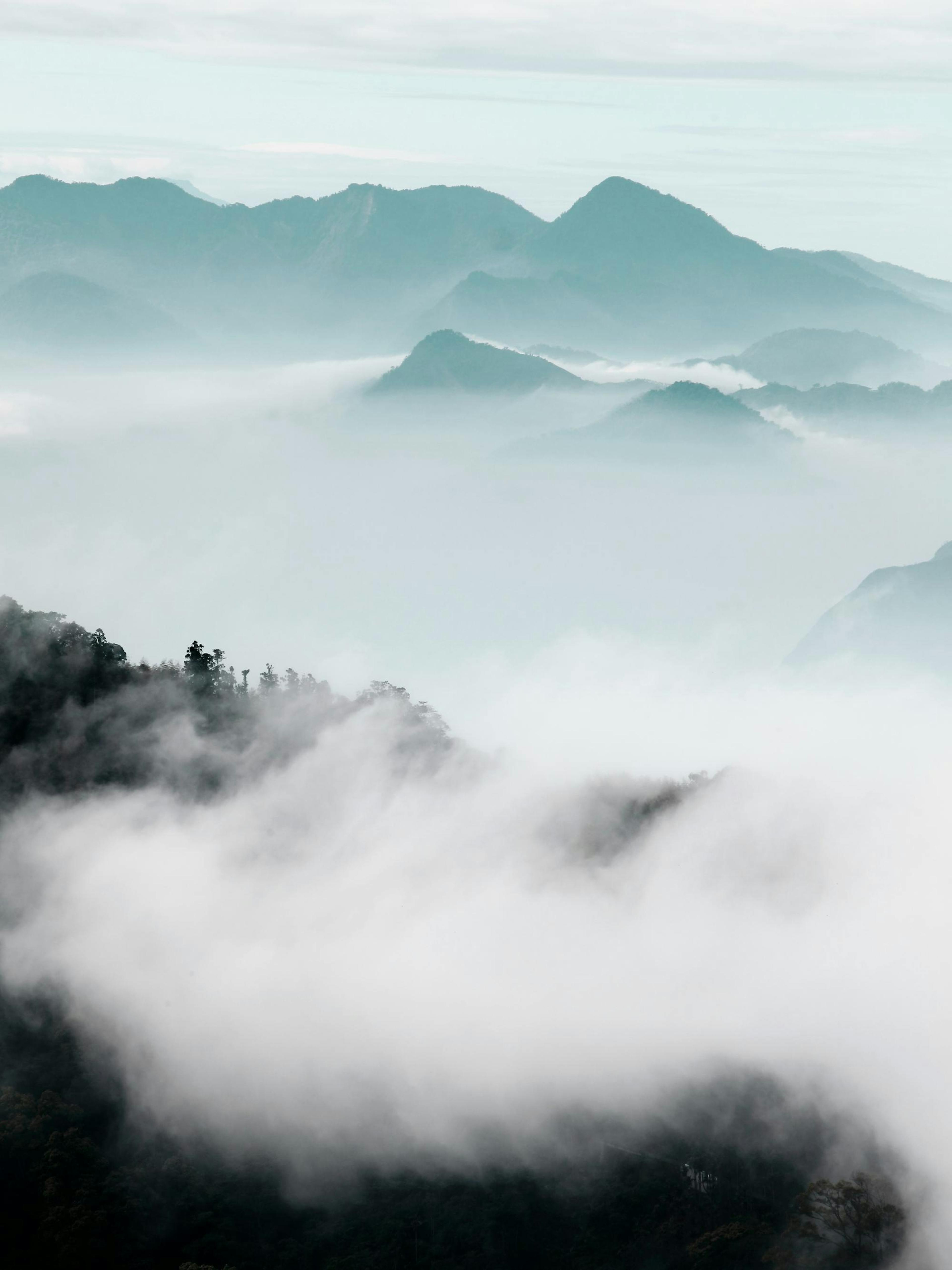 Photographic poster of misty mountain peaks shrouded in clouds, creating a serene and ethereal landscape