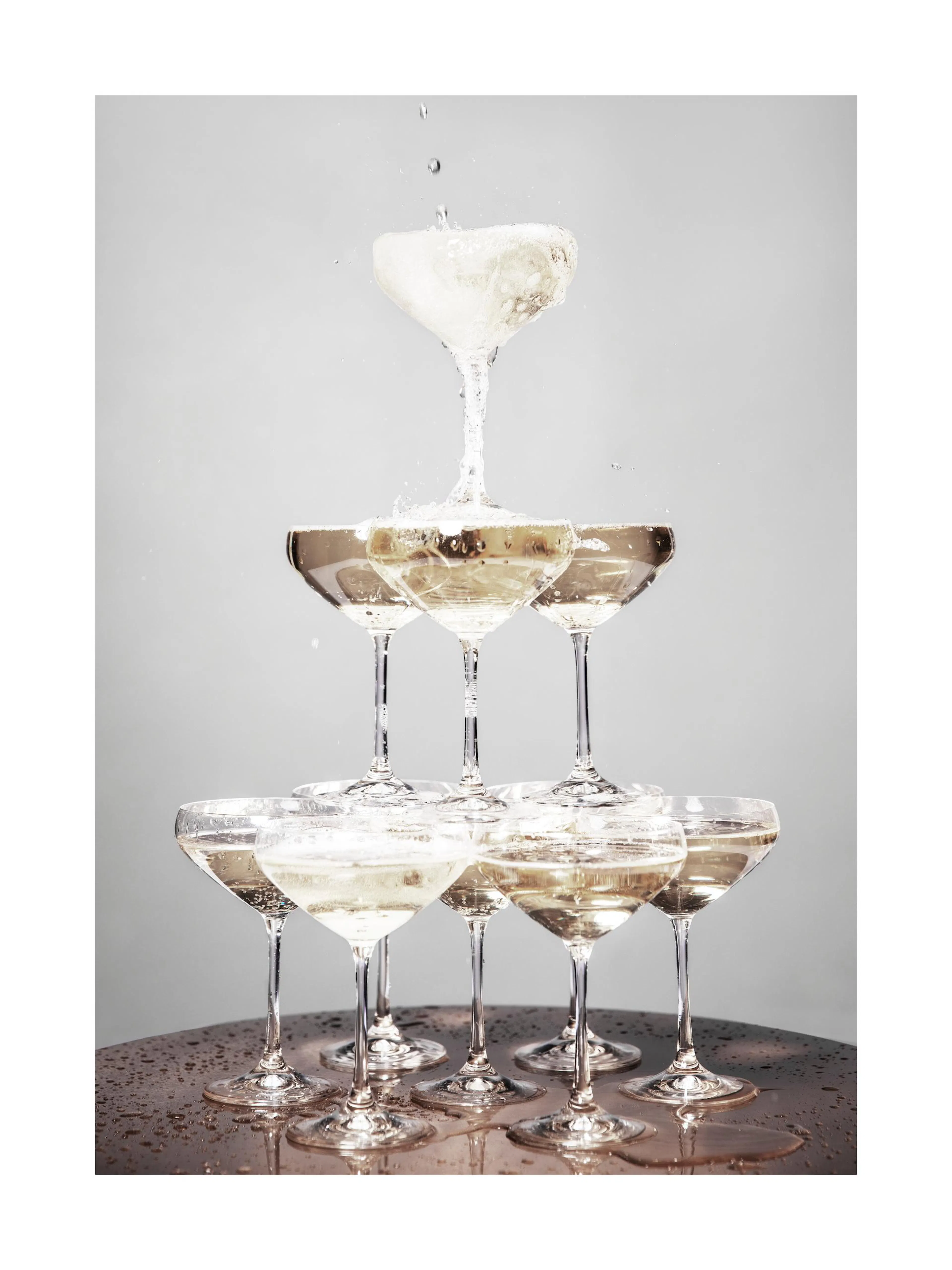 Affiche de pyramide de coupes de champagne, avec du liquide qui déborde et éclabousse, sur fond gris clair