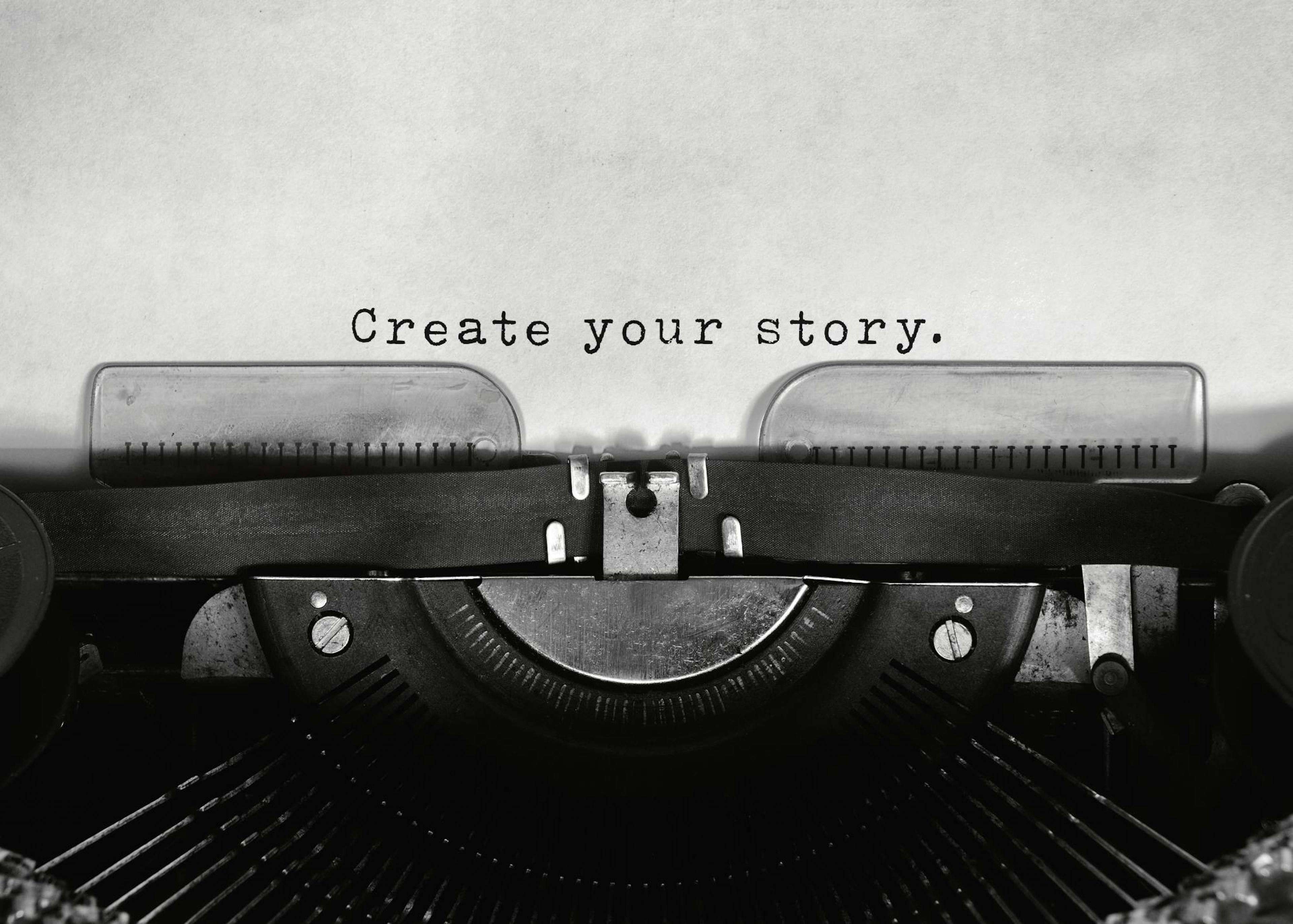 Black and white poster featuring a vintage typewriter with the words Create your story typed on white paper.
