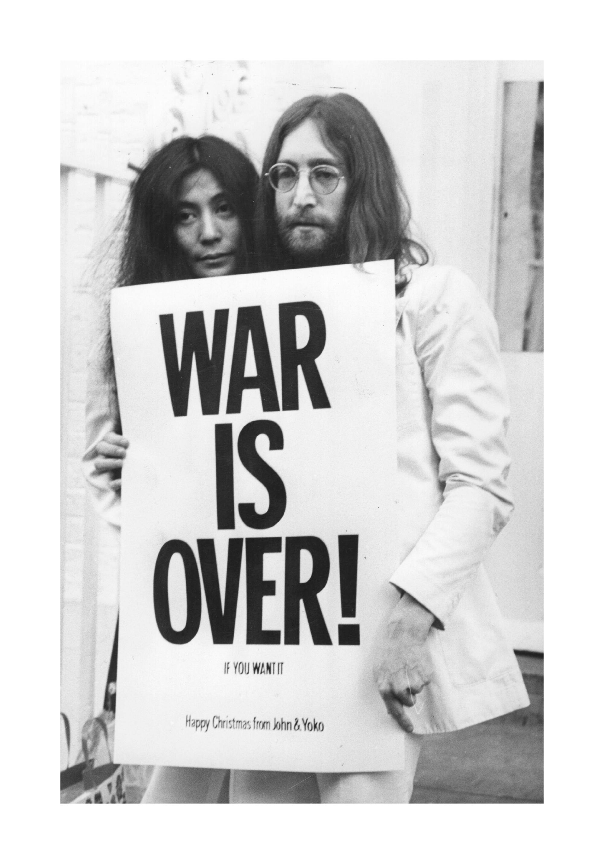 Svartvitt fotografi av John Lennon och Yoko Ono som håller en War is Over skylt, ikonisk fredskampanj