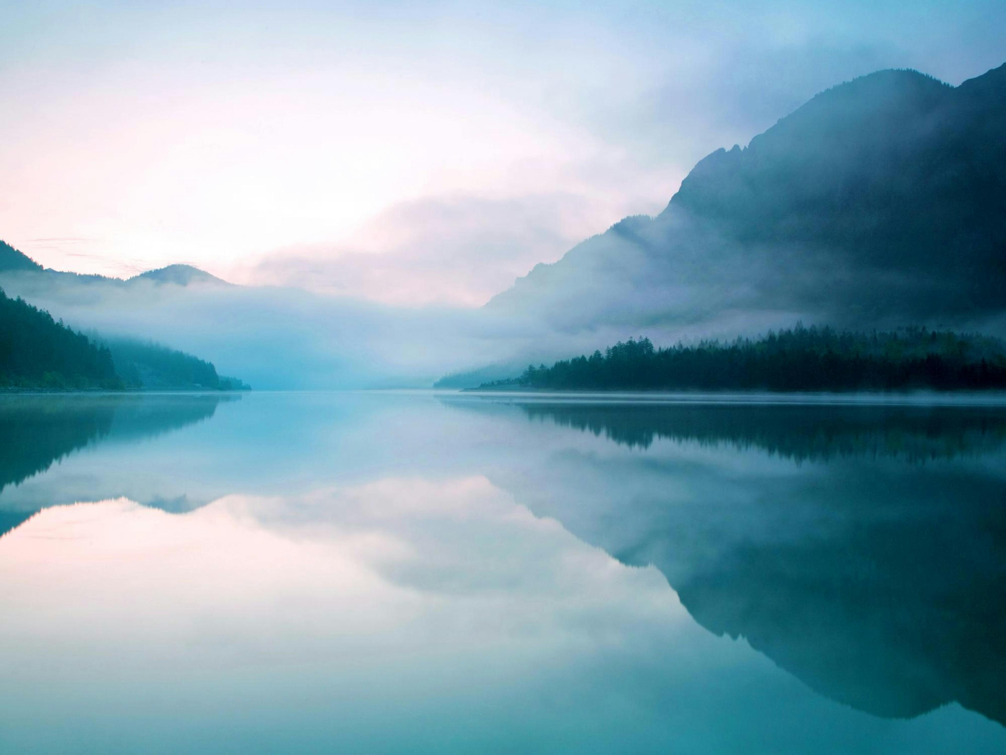 Plakat des Plansees in Österreich, blaugrünes Wasser mit Spiegelung, neblige Berge und Bäume im Hintergrund.