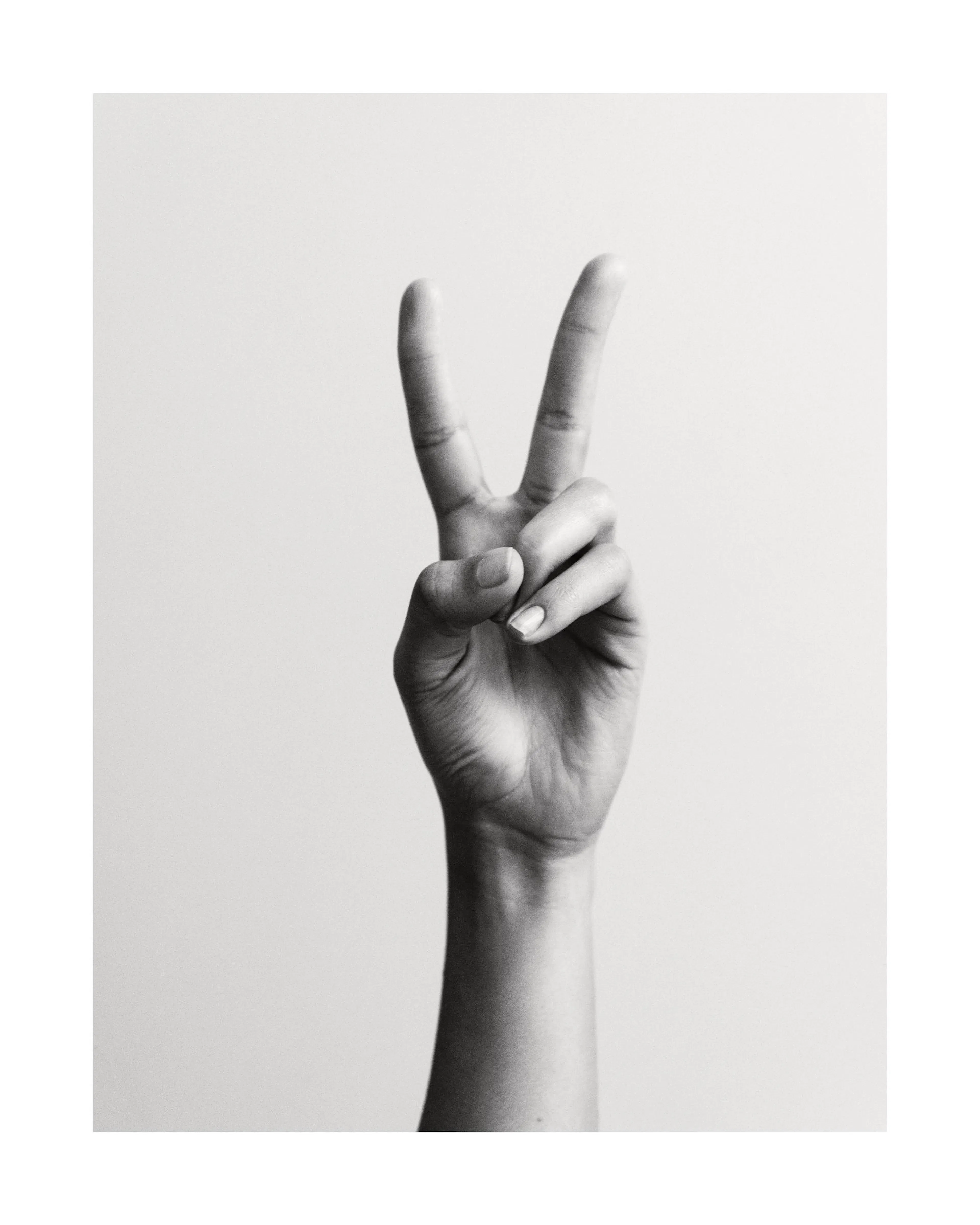 Affiche noir et blanc dune main faisant le signe de la paix avec une typographie simple et claire