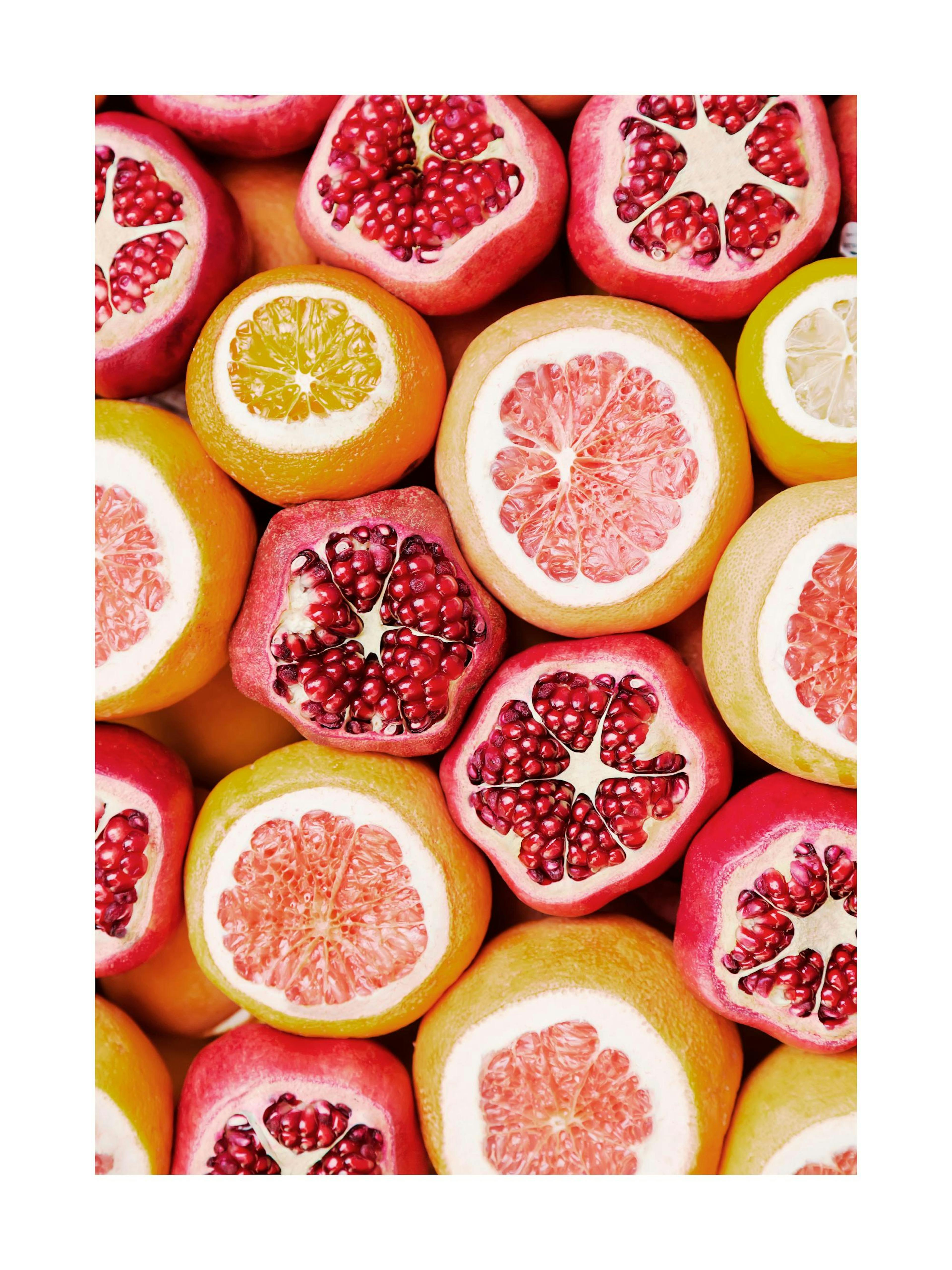 Poster mit aufgeschnittenen Orangen, Grapefruits und Granatäpfeln in lebendigen Farben