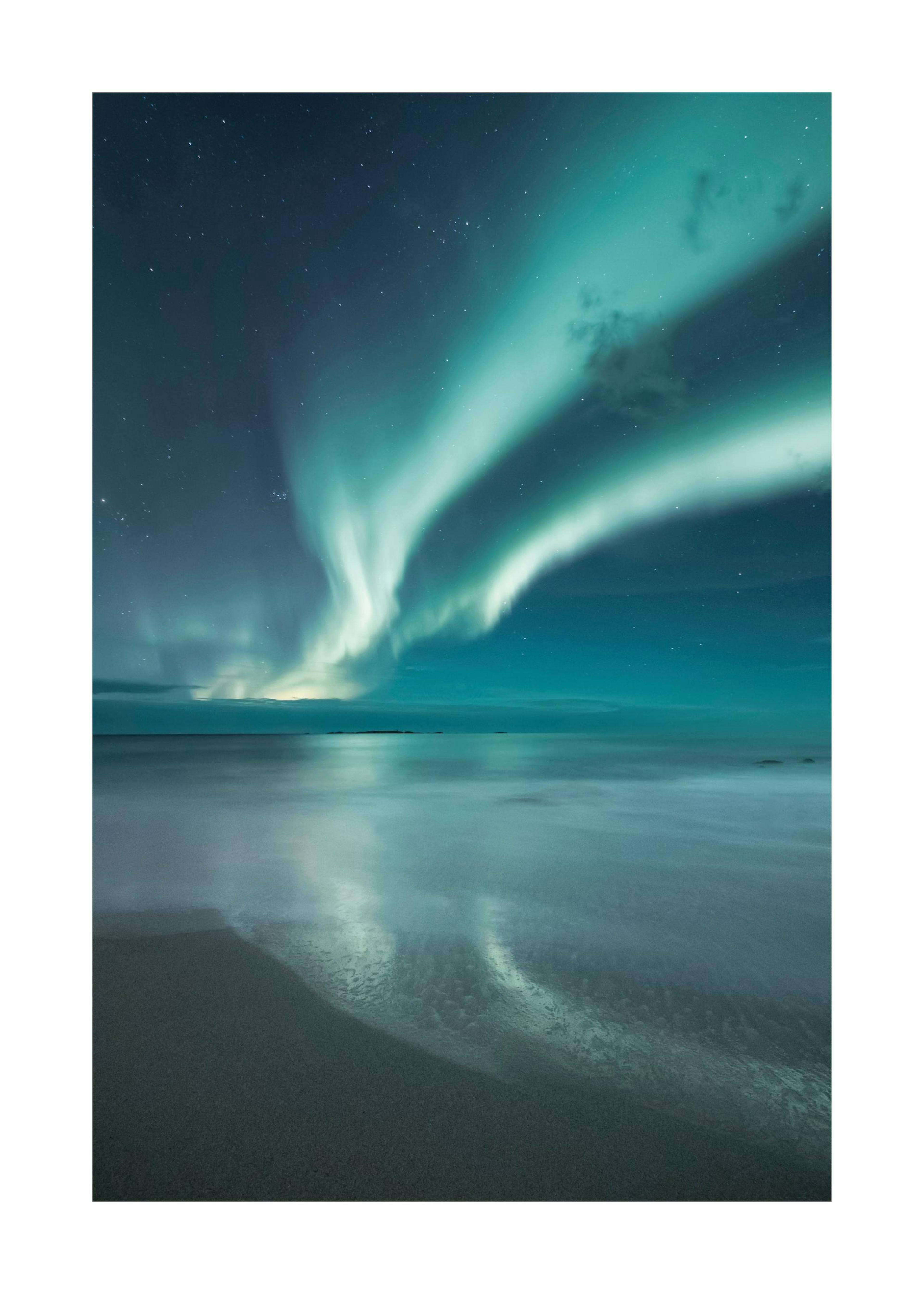 砂浜と海に映る青いオーロラの夜景写真