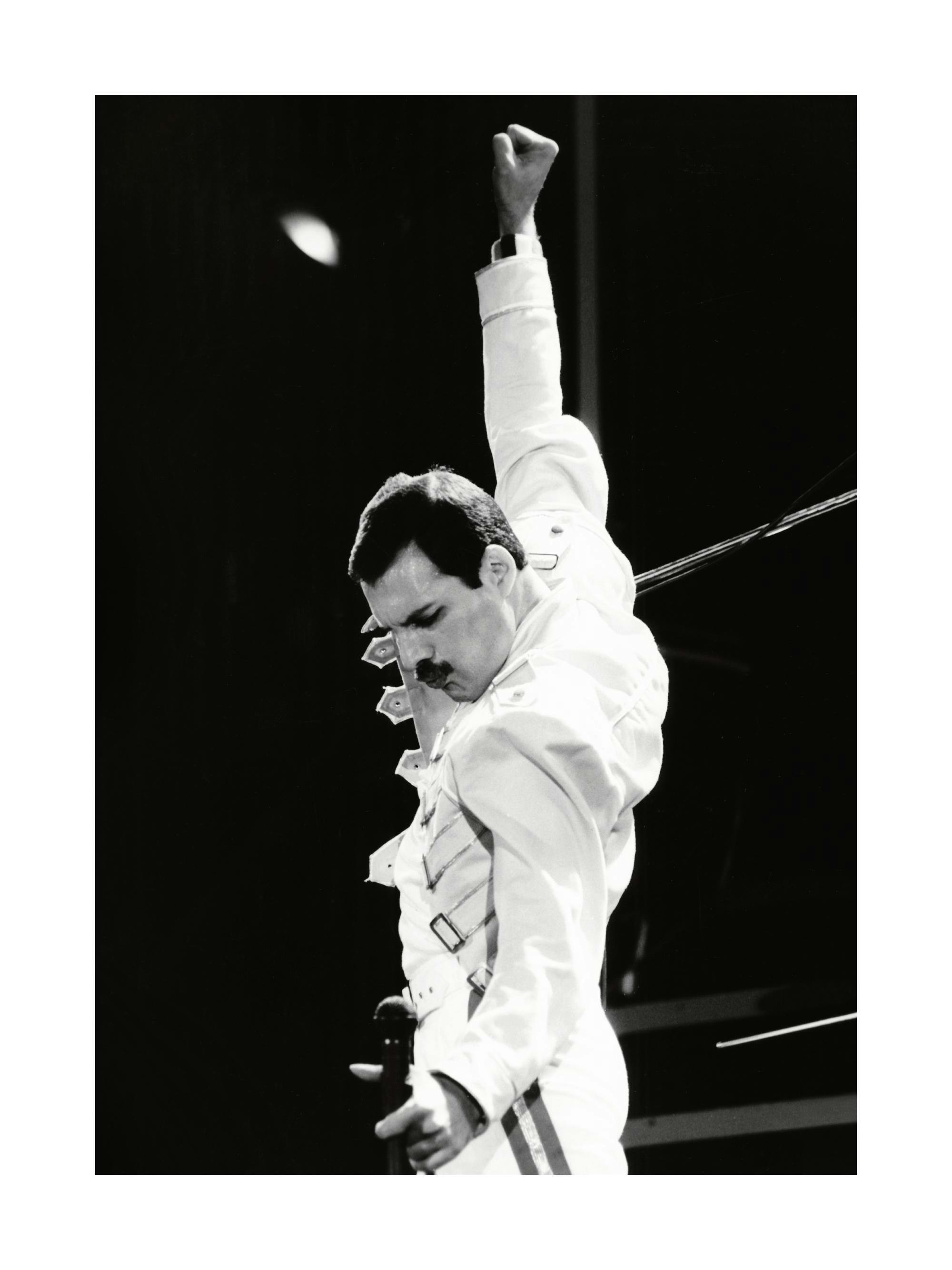 Poster preto e branco de Freddie Mercury dos Queen, de braços erguidos, a cantar no palco