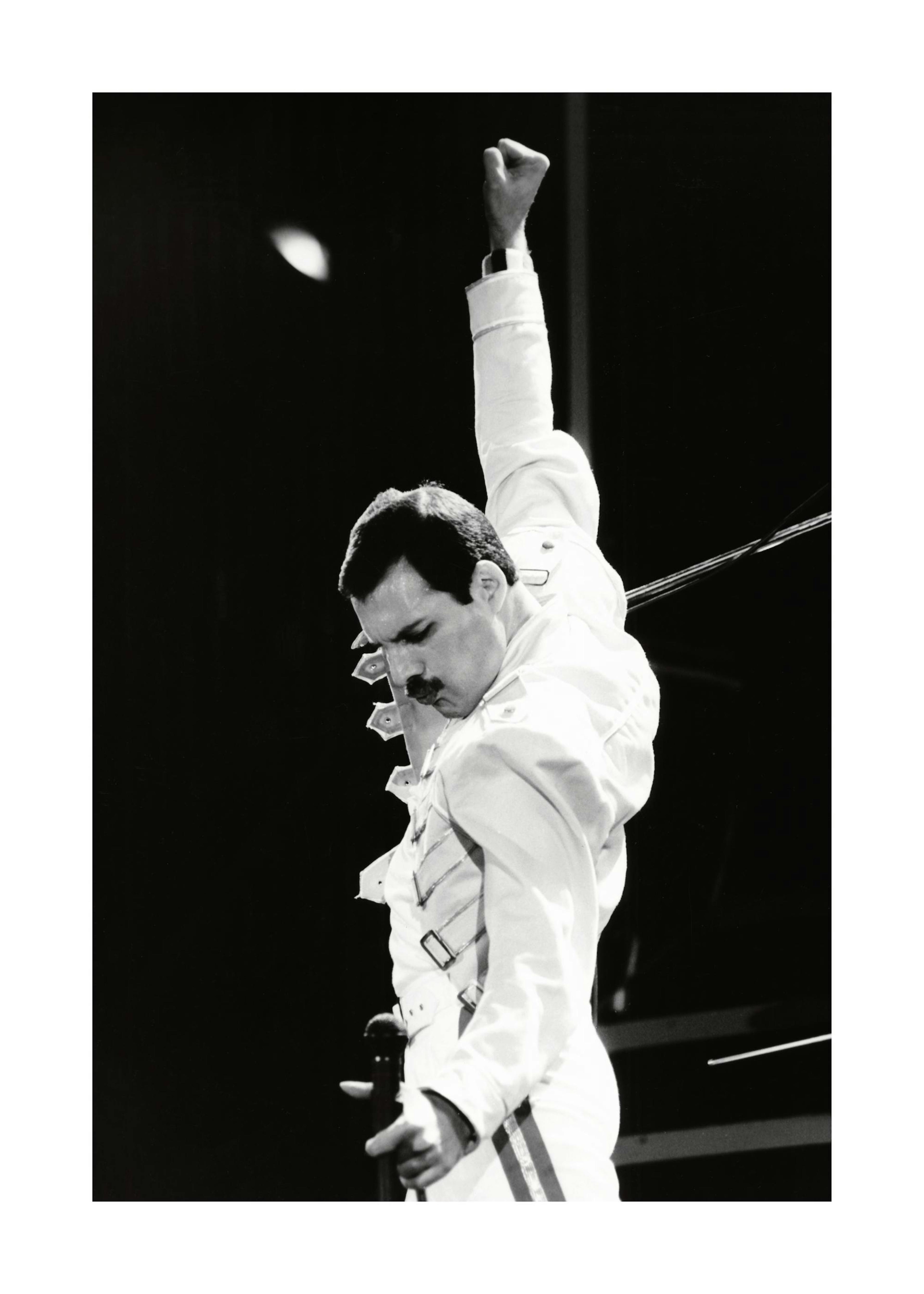 Póster de Freddie Mercury de Queen en blanco y negro, con traje blanco, micrófono y brazo alzado.