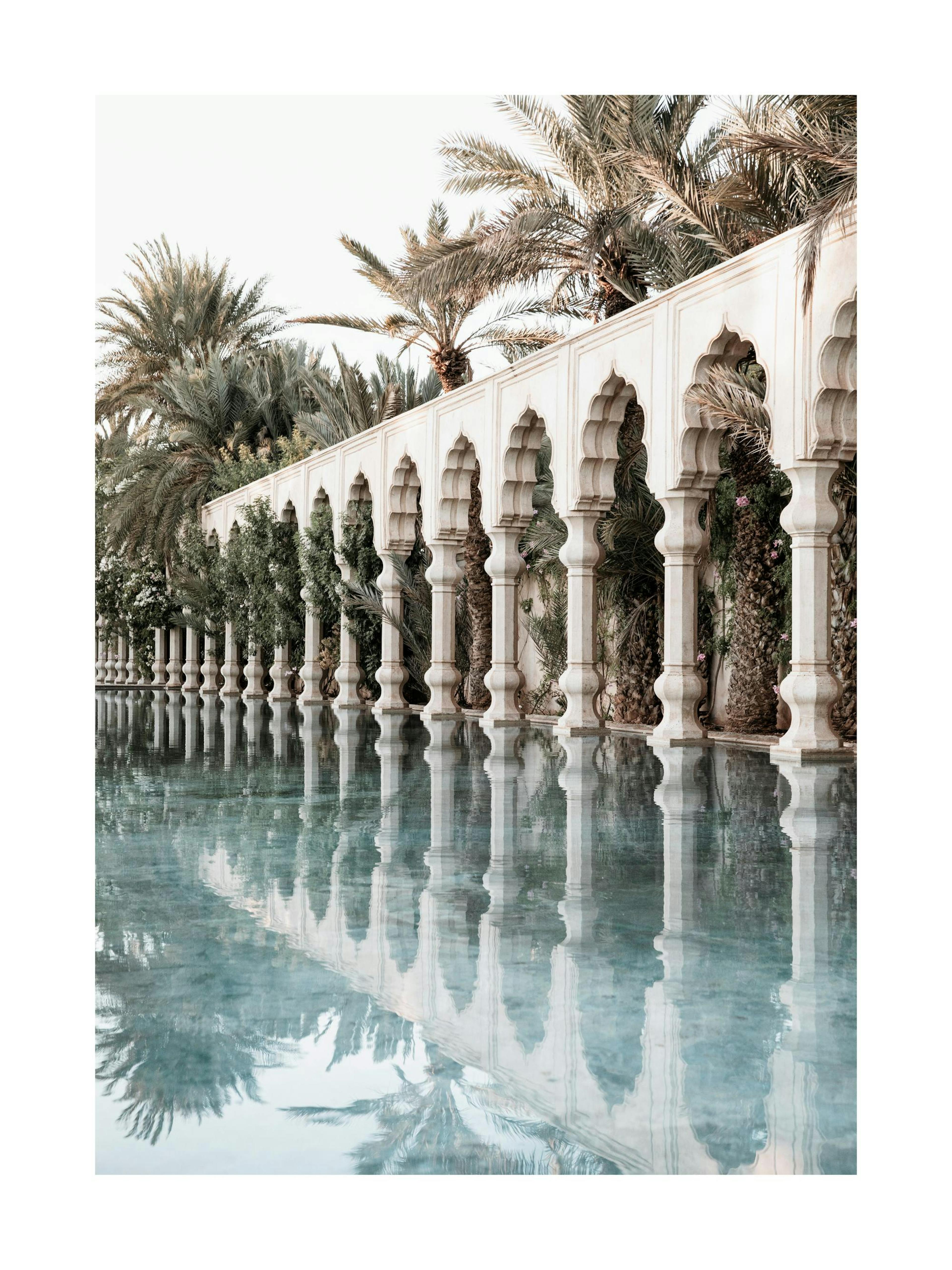 Print of white pillars, curved arches, and palm trees reflected in a pool, ideal as a poster print.