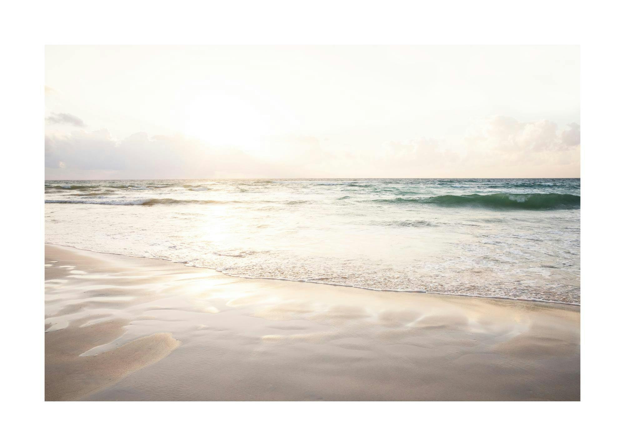 Ocean beach photography at sunset with soft sunlight and muted pastel hues.