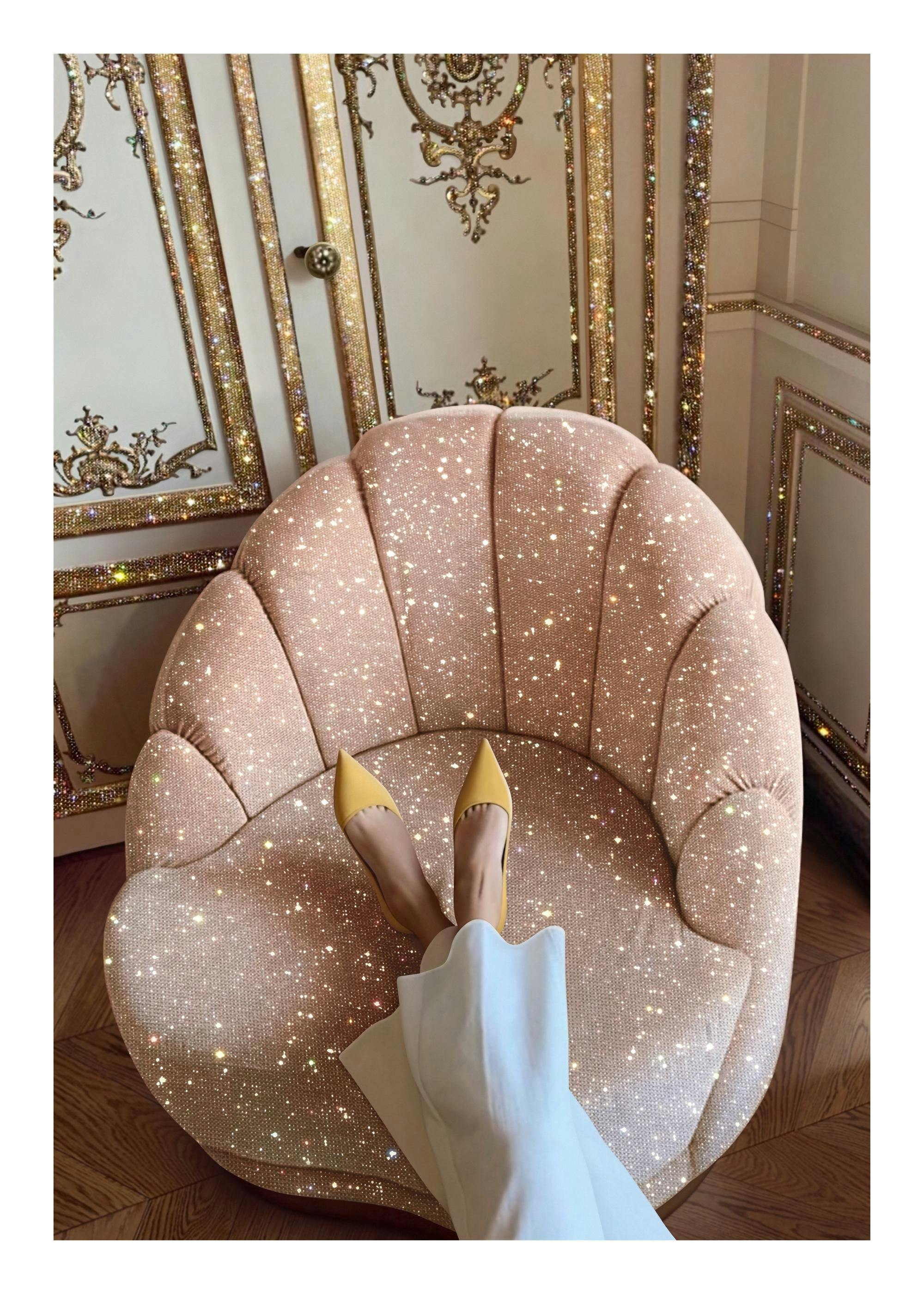 Fotografi av en kvinna med gula högklackade skor som vilar fötterna på en glittrig rosa stol framför en vägg i guld och vitt.
