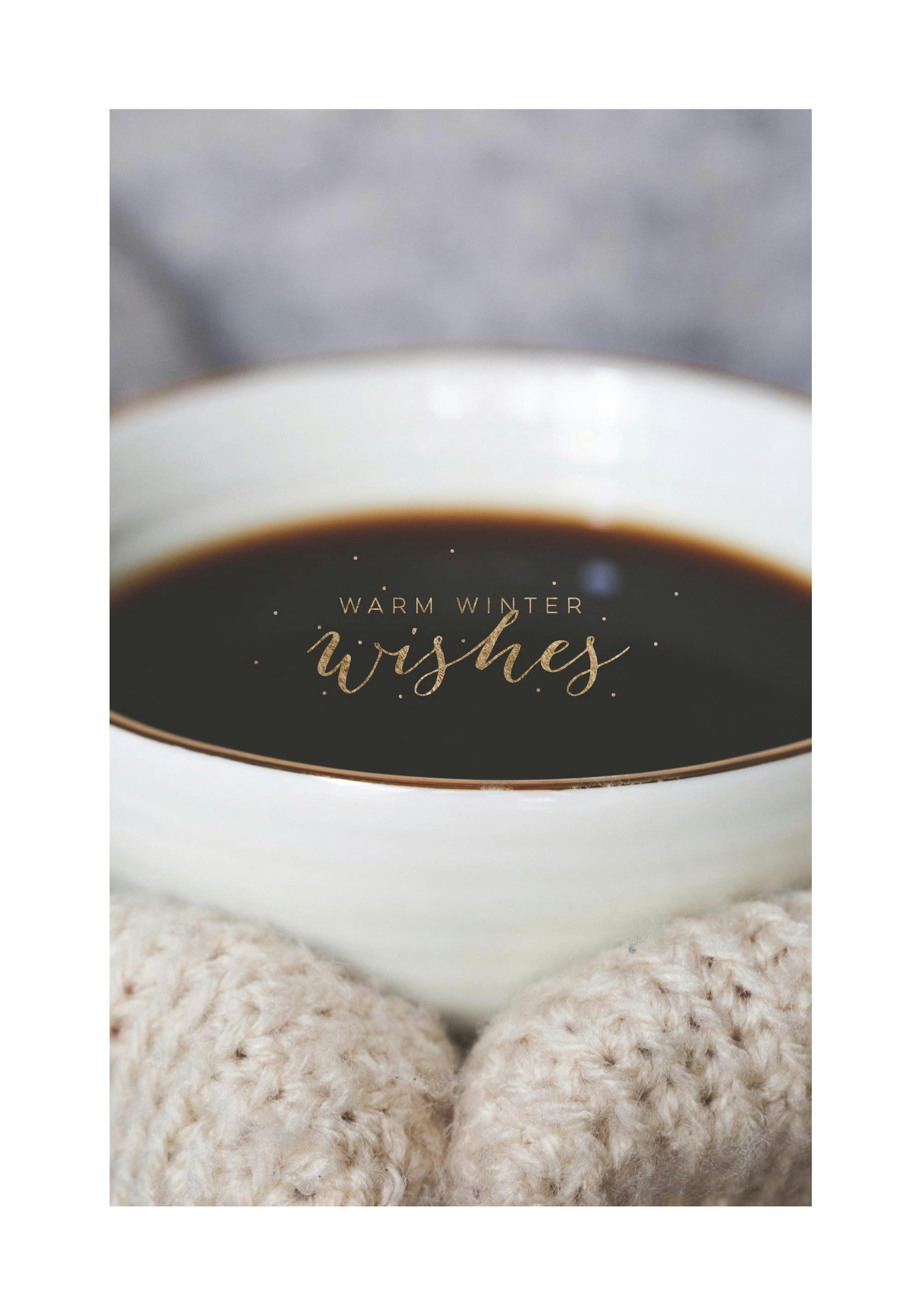Coffee cup print with gold Warm Winter Wishes text, held by hands in knitted mittens.