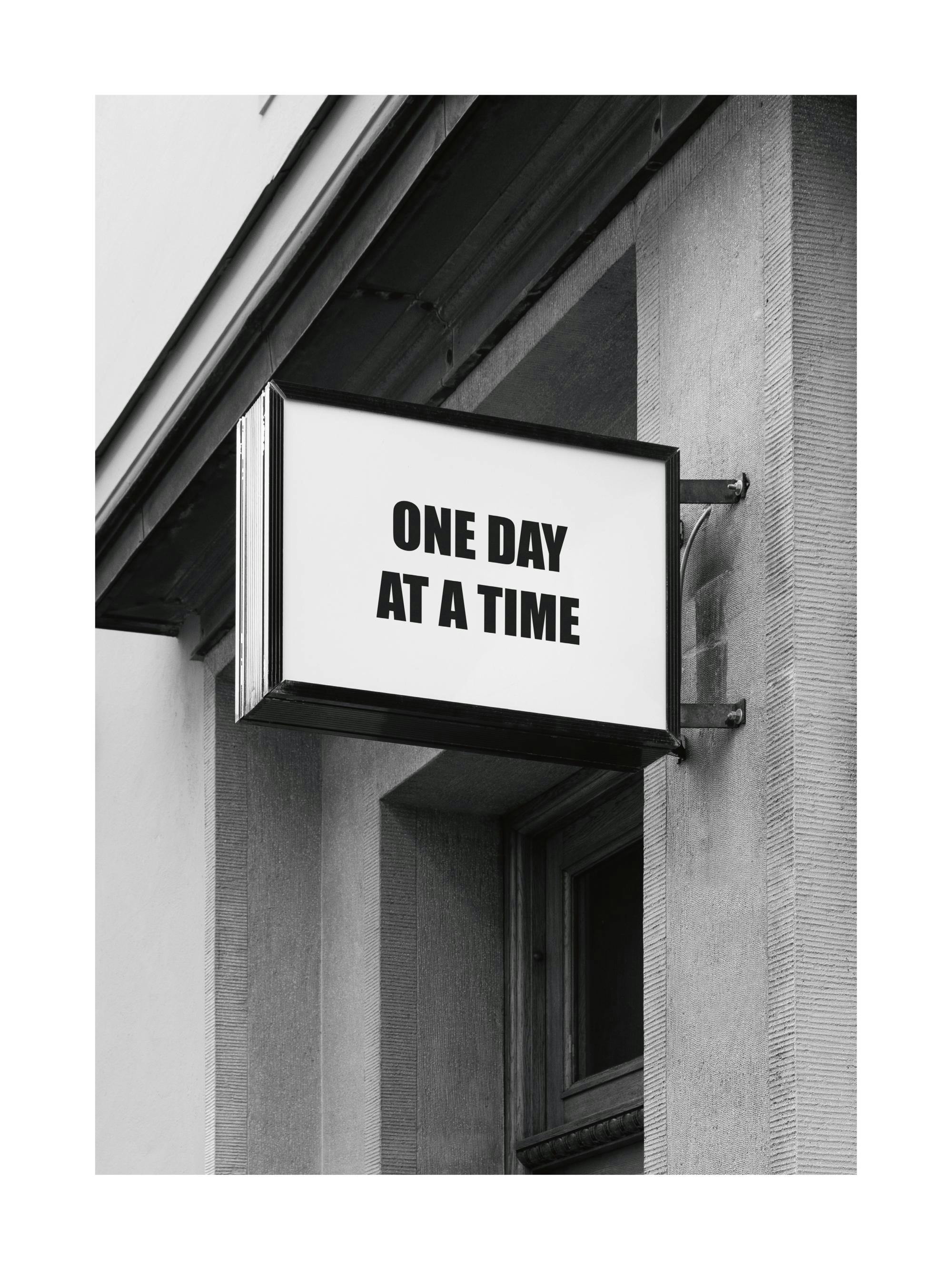 Affiche noir et blanc photographie dune enseigne lumineuse avec le texte One Day at a Time