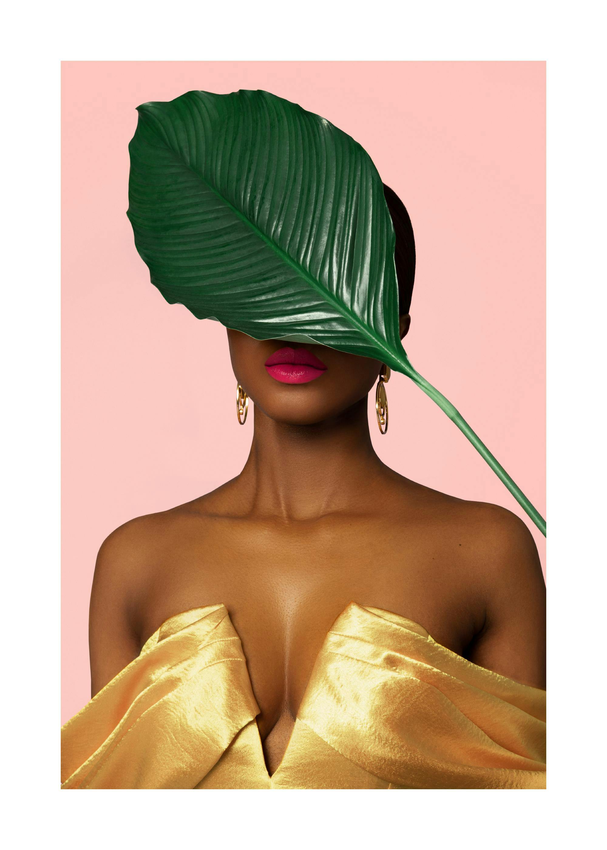 Poster donna abito dorato ed orecchini, occhi coperti da foglia verde, labbra rosa vivace