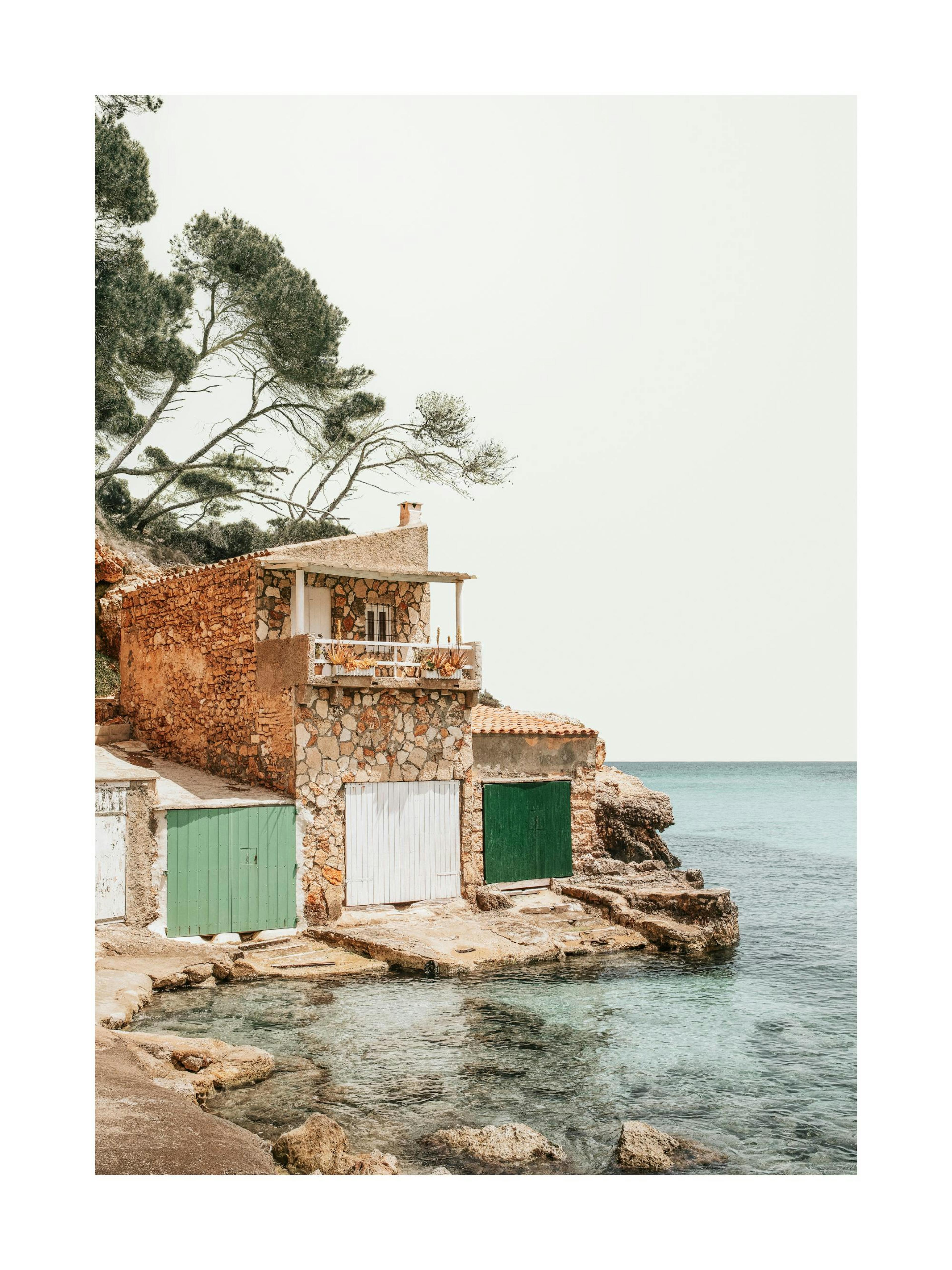 Båthus i stein med grønne og hvite dører på Mallorca, Spania