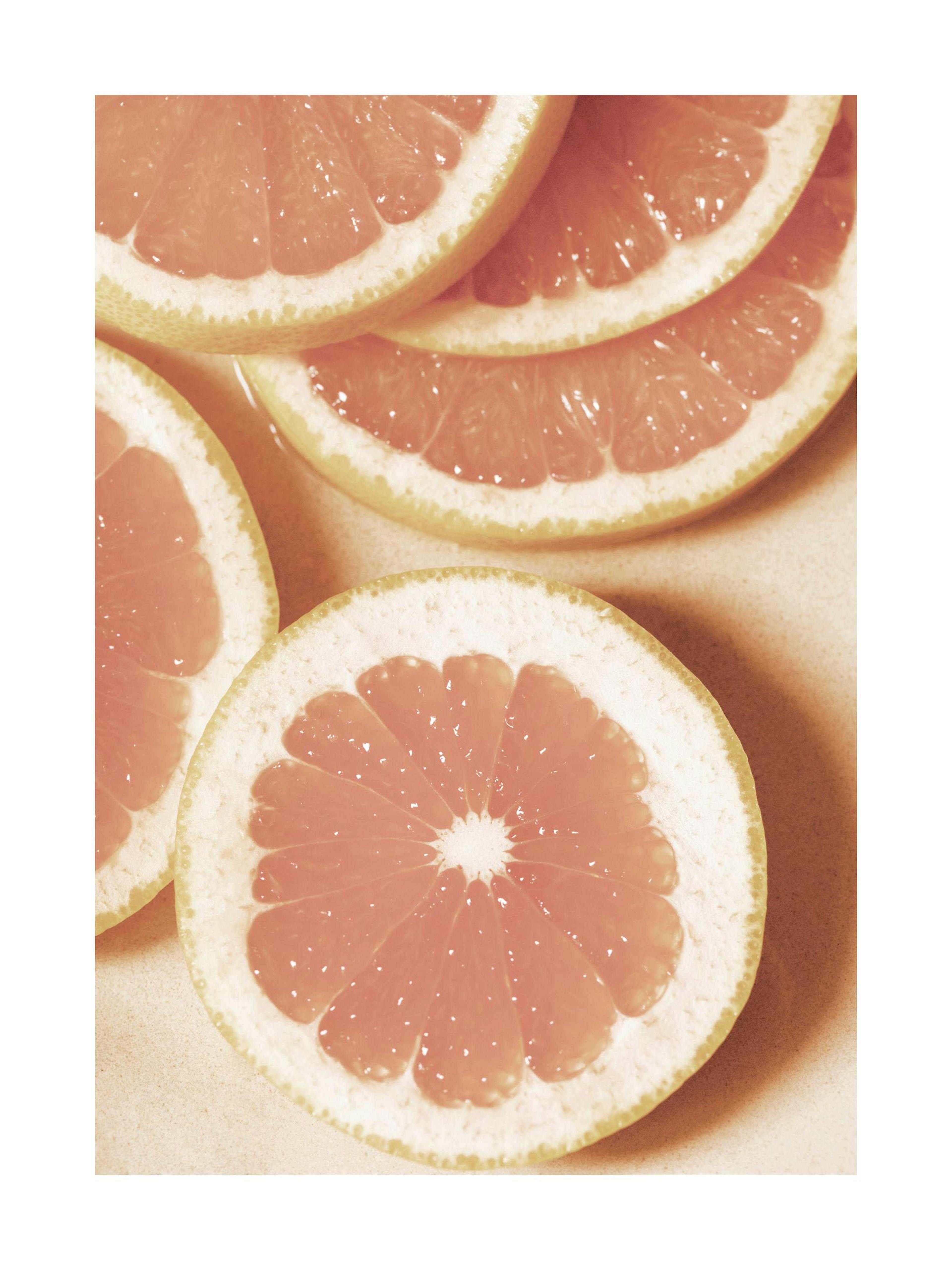 Póster de pomelos en rodajas, fotografía macro de cítricos rosados en tonos anaranjados, arte de cocina.