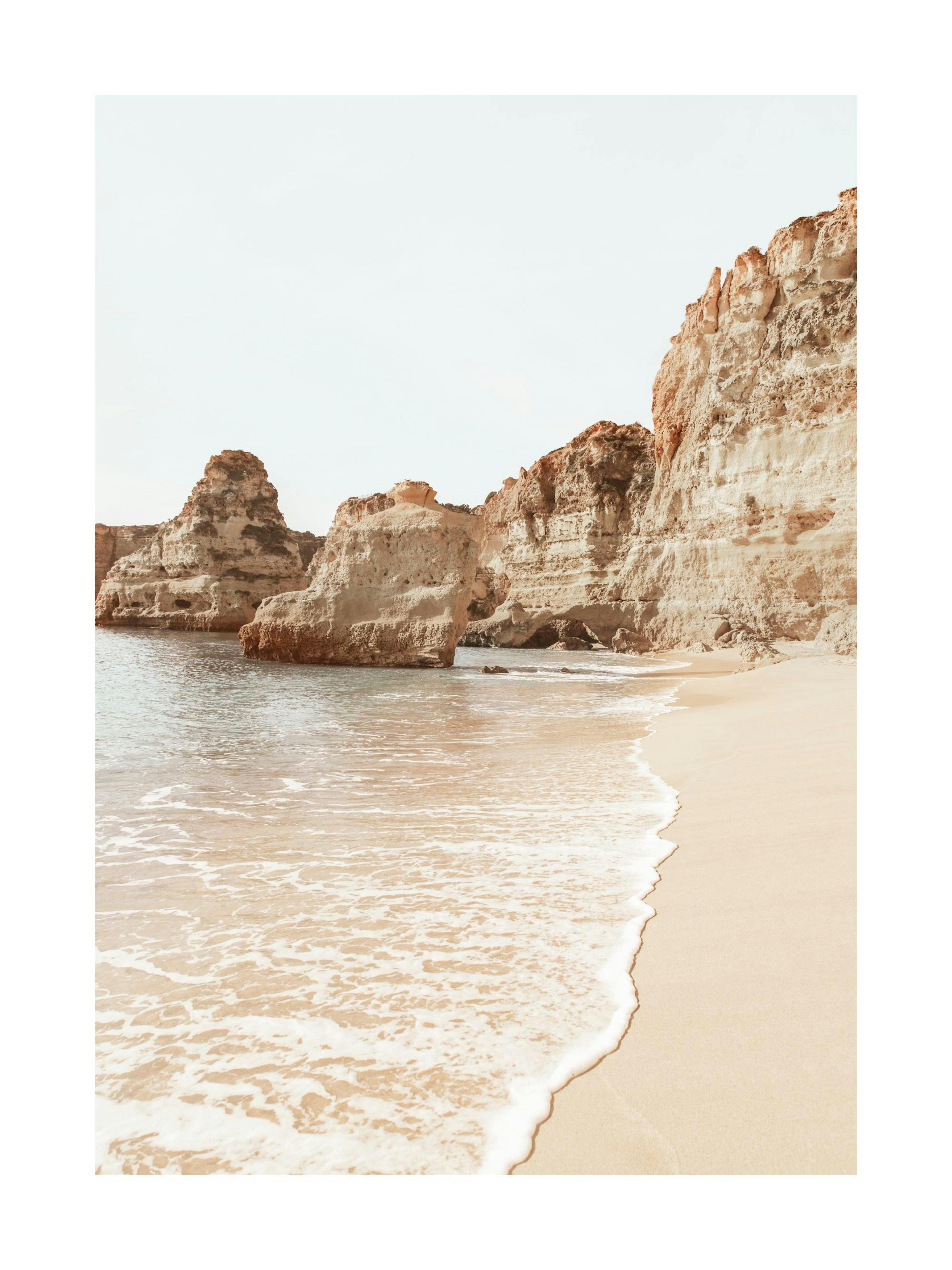 Fotografie eines Algarve Strandes mit beigen Felsen und weisser Brandung auf beigem Sand