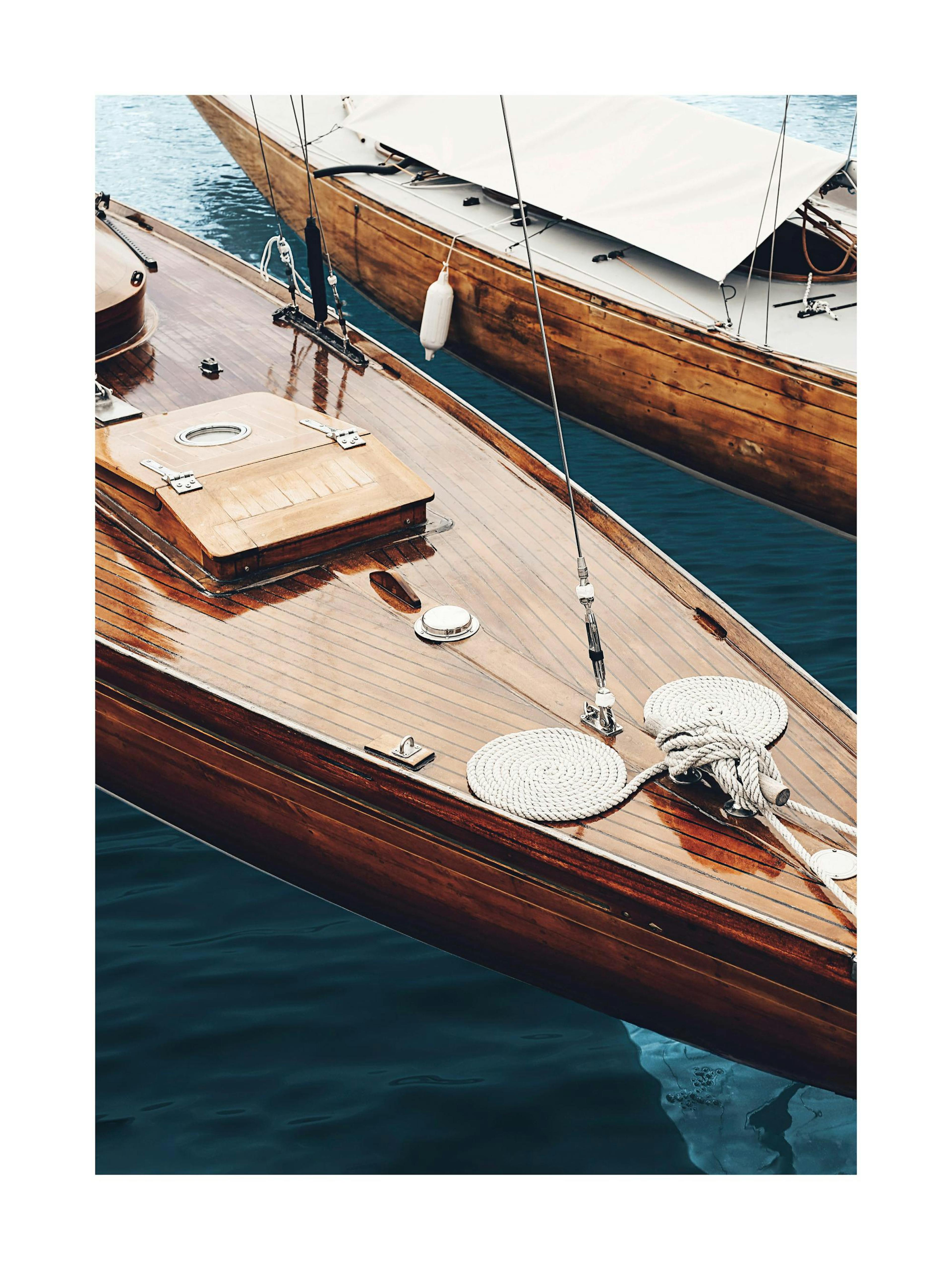 Photograph of two classic wooden boats on the water, showing rich wood grain and coiled ropes. Boat print poster.