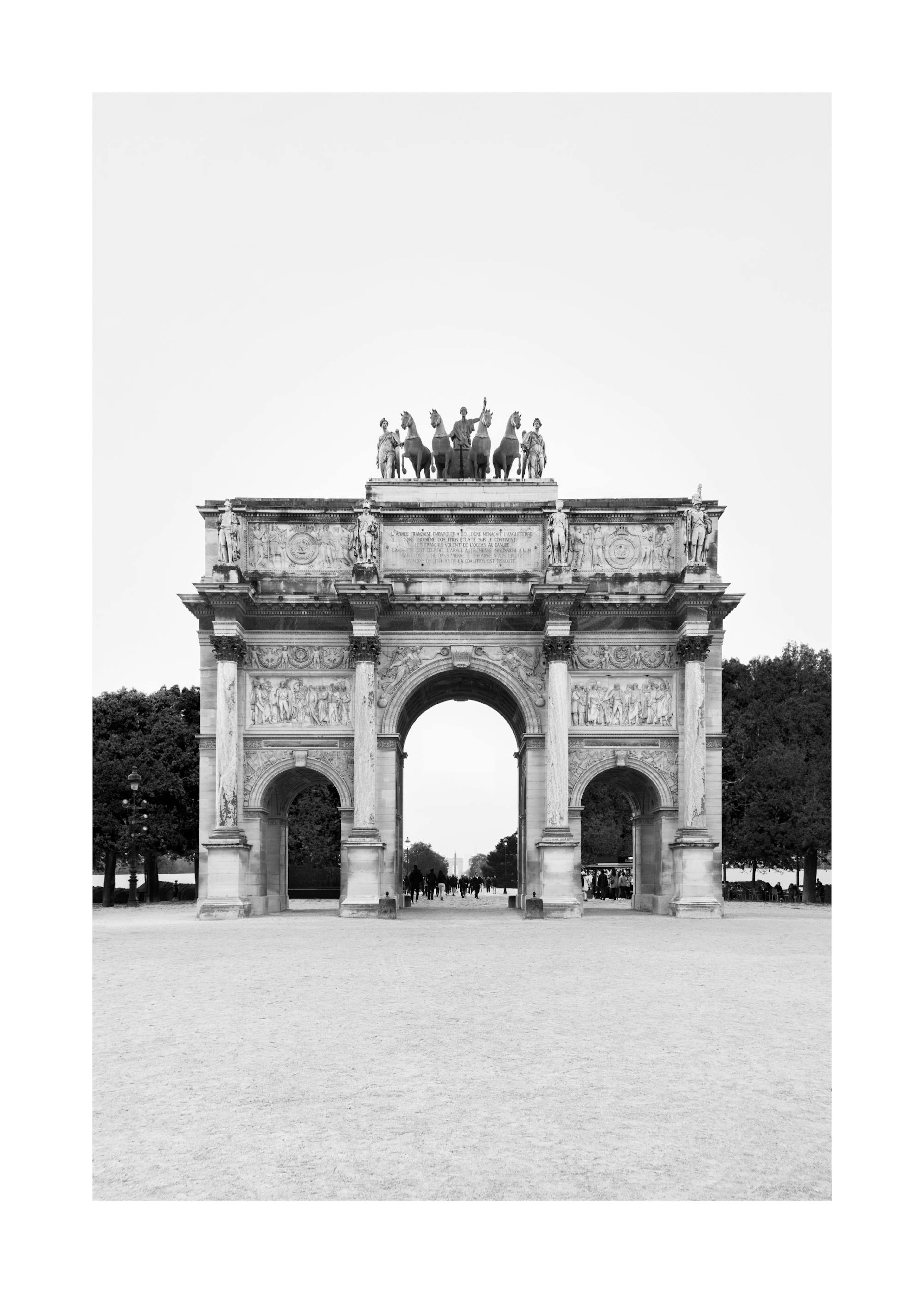 Black and white photograph of the Arc de Triomphe du Carrousel, a stately arch with sculptures on top, ideal print or poster.