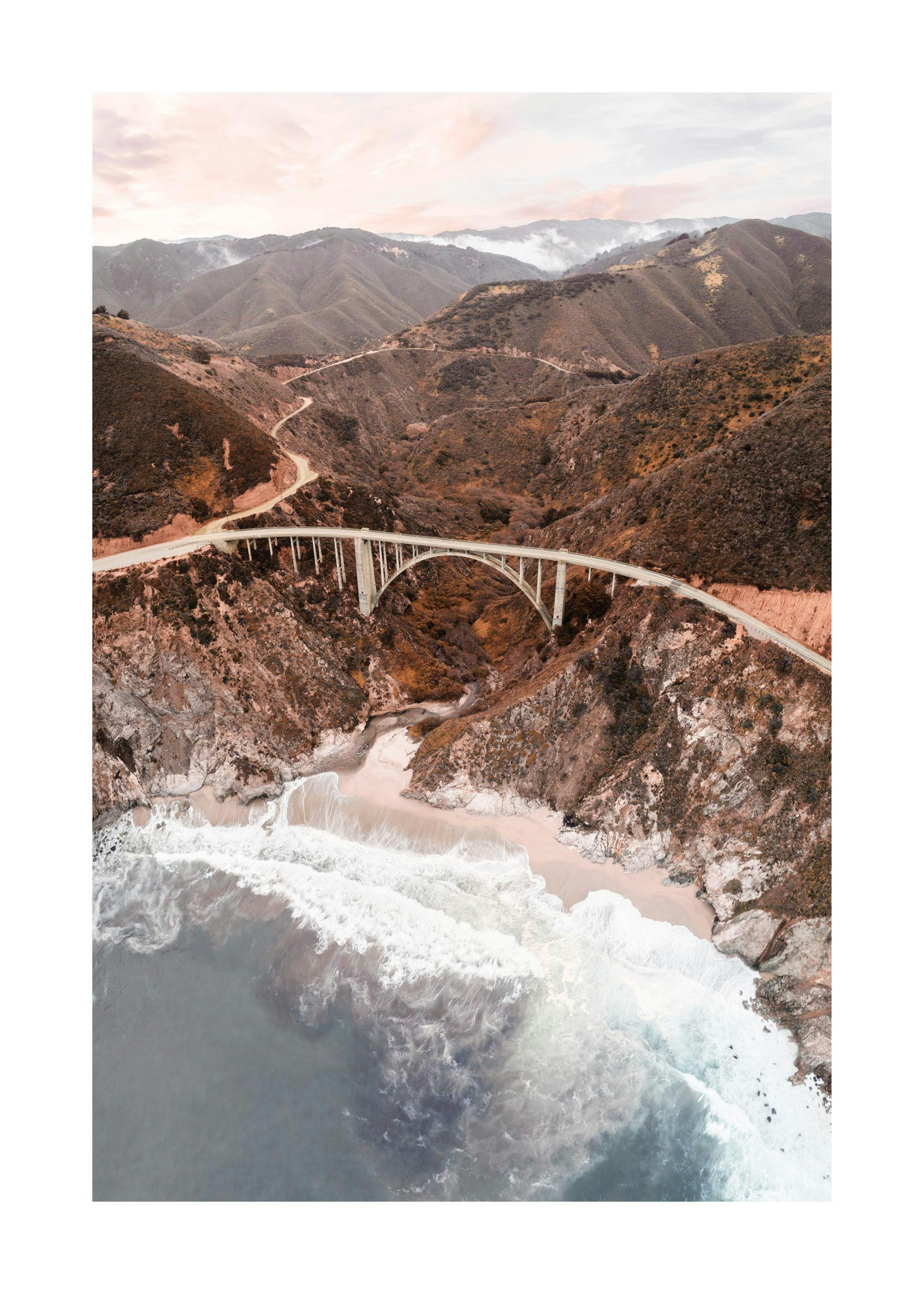 Póster puente Bixby Creek, Big Sur, California, con montañas y playa de arena, olas rompiendo, cielo rosado
