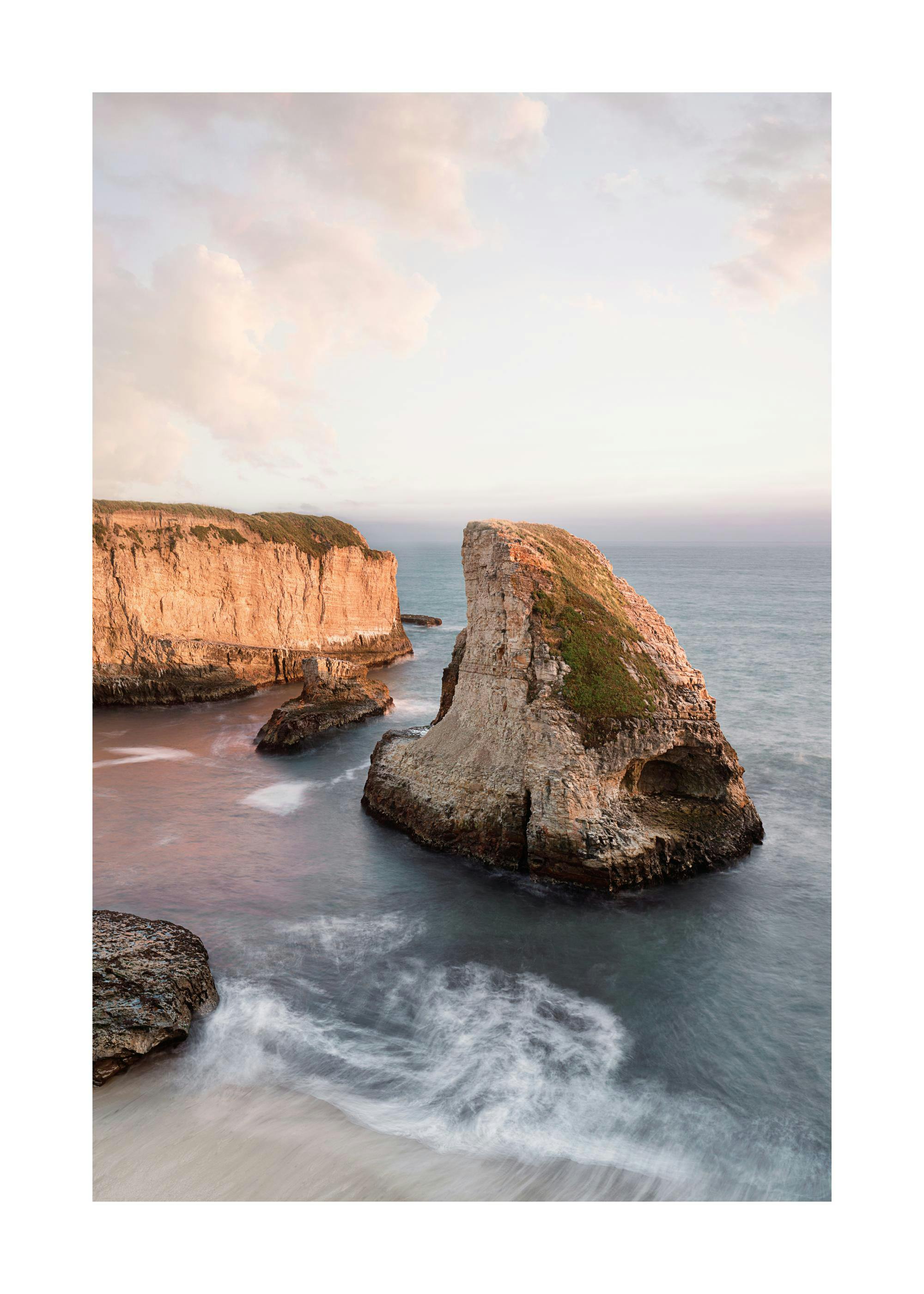 Póster Shark Fin Cove com falésias rochosas e água suave, céu crepuscular e ondulação da água na praia
