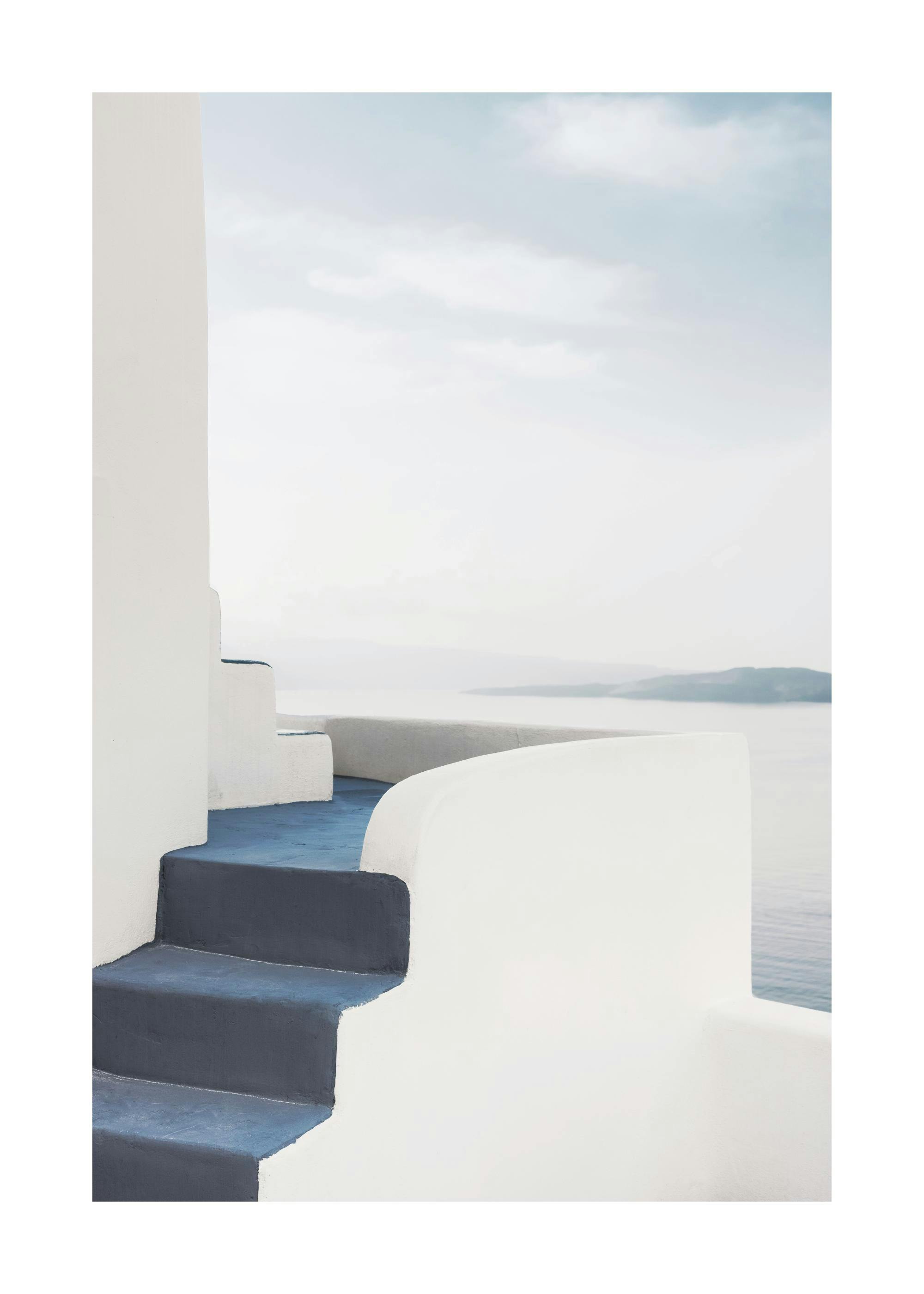 Affiche avec des escaliers bleus et des murs blancs menant à un chemin incurvé au-dessus de locéan
