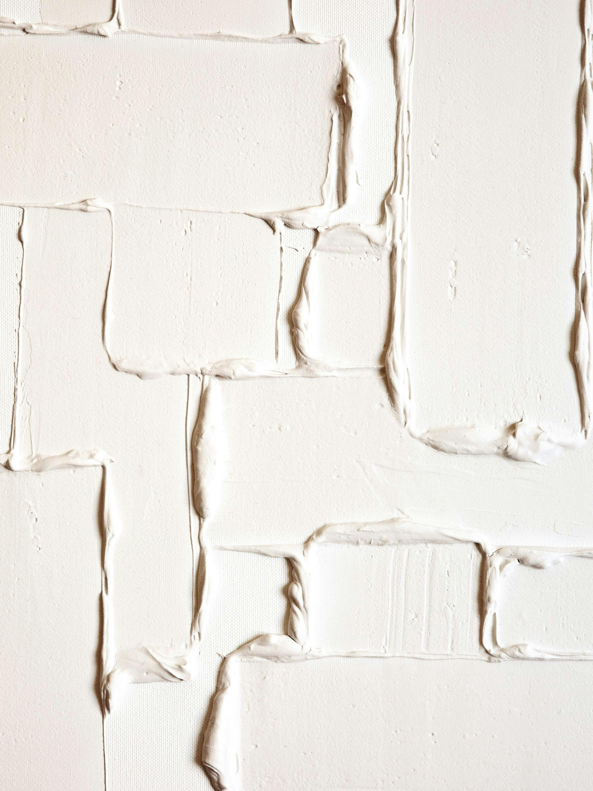 Beige texturkonst med upphöjda block på duk. Abstrakt design med rektangulära former skapar ett trendigt mönster.