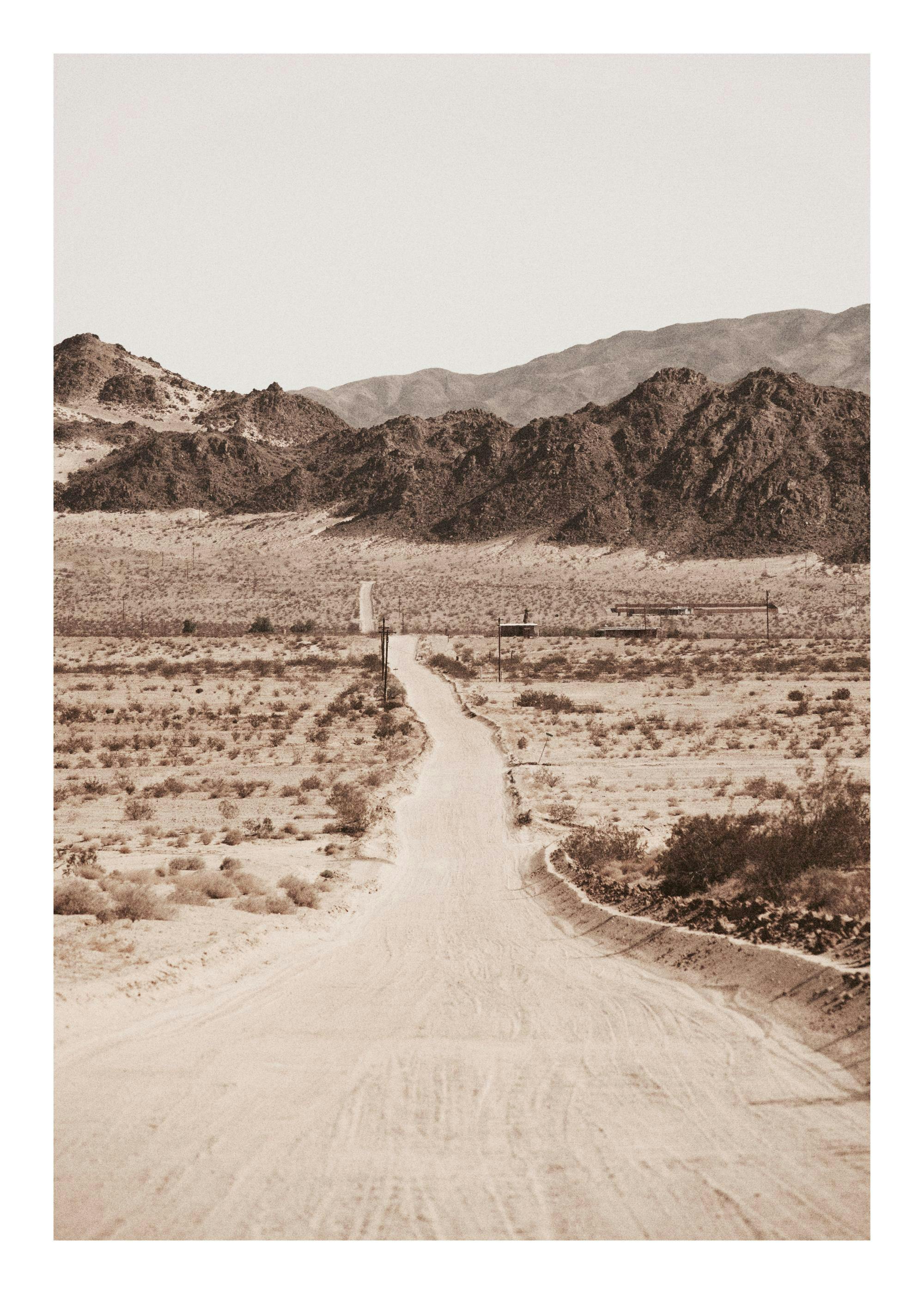 Sepia tone desert road print with mountains in background poster