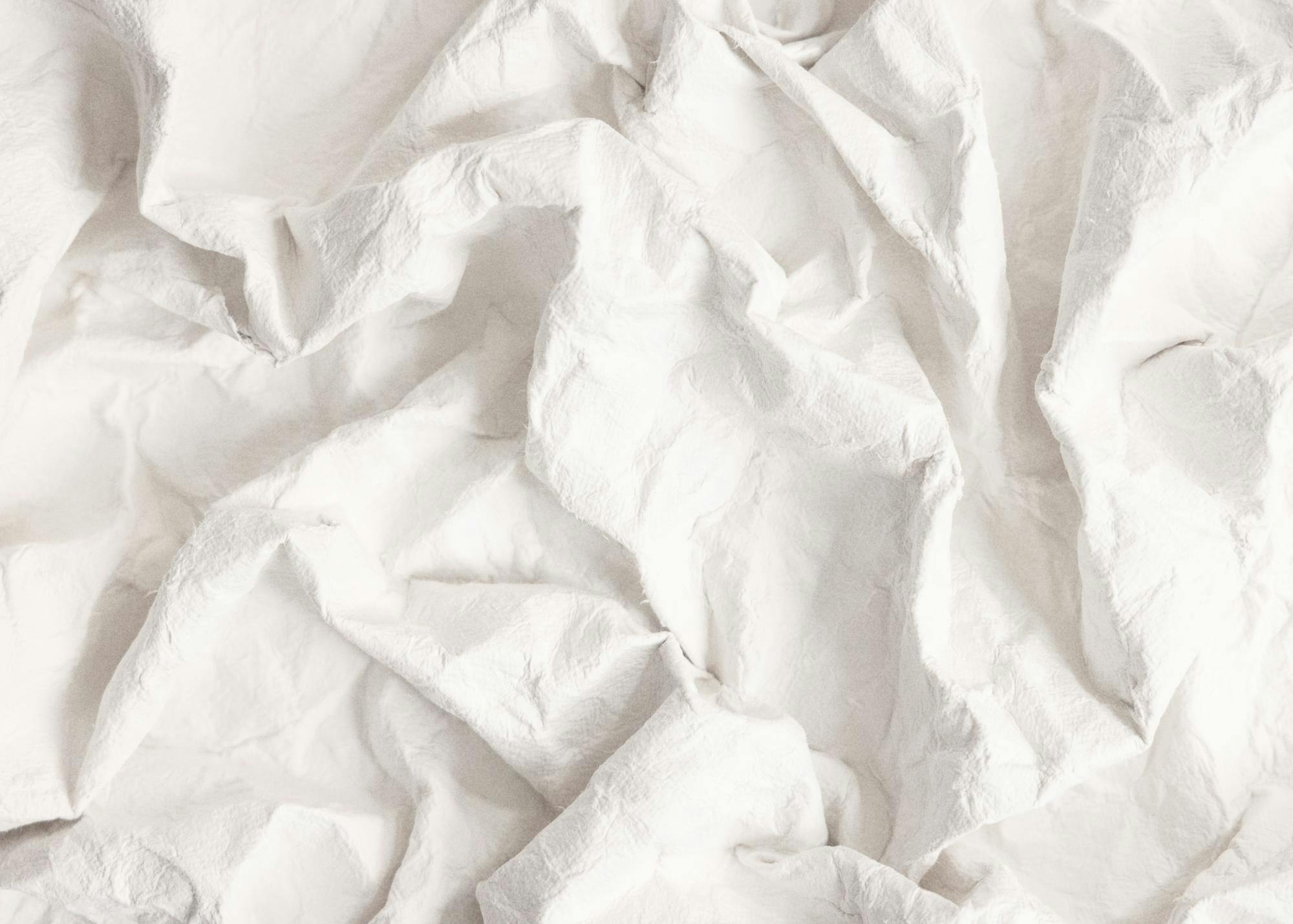 Gefaltetes weisses Papier, Nahaufnahme, zerknitterte Textur, Papierfalten, detaillierter Druck, weisse Farbpalette