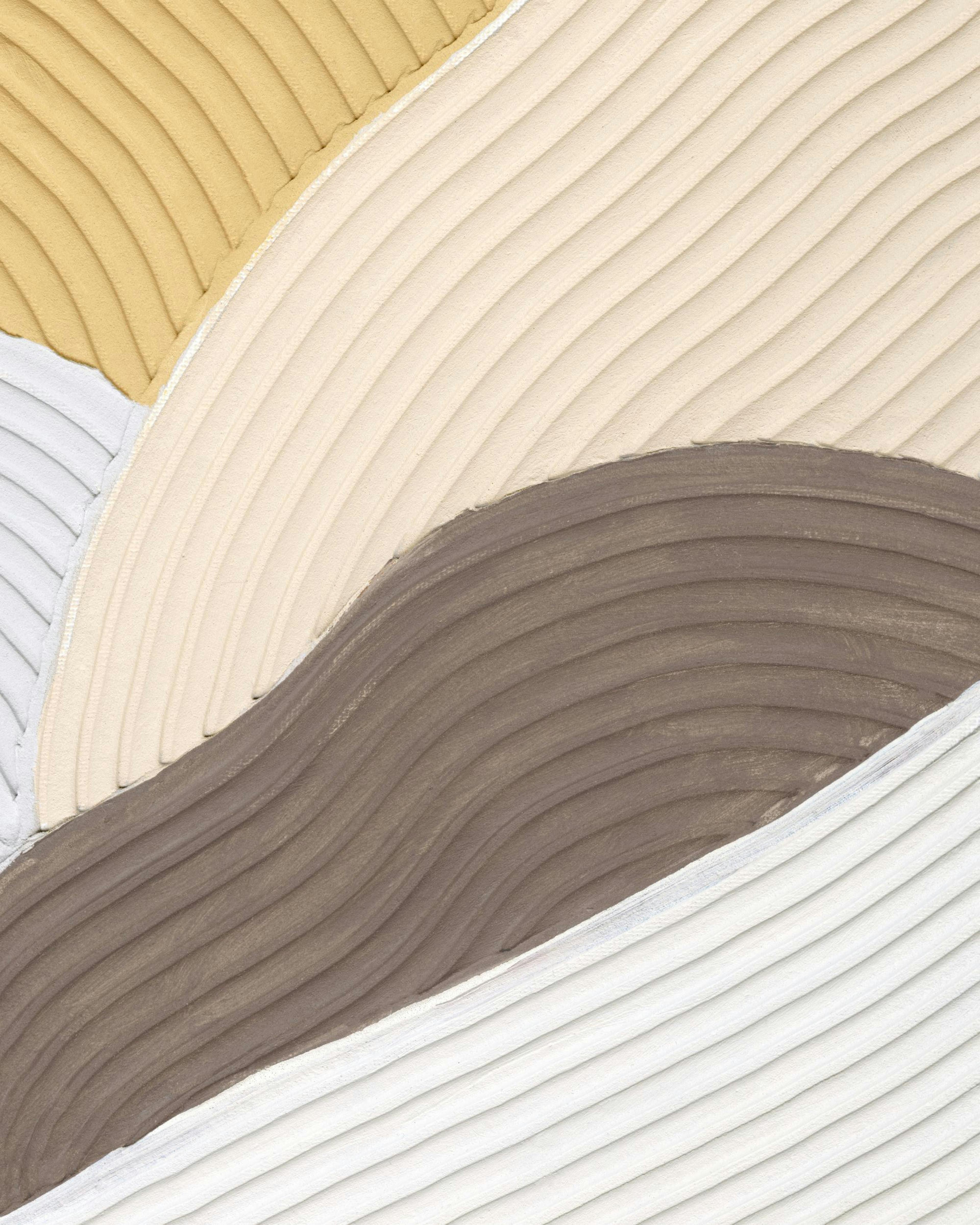 Affiche aux formes ondulées texturées beige, marron et blanc, accrochée au mur jaune dun salon avec un canapé et un lampadaire.