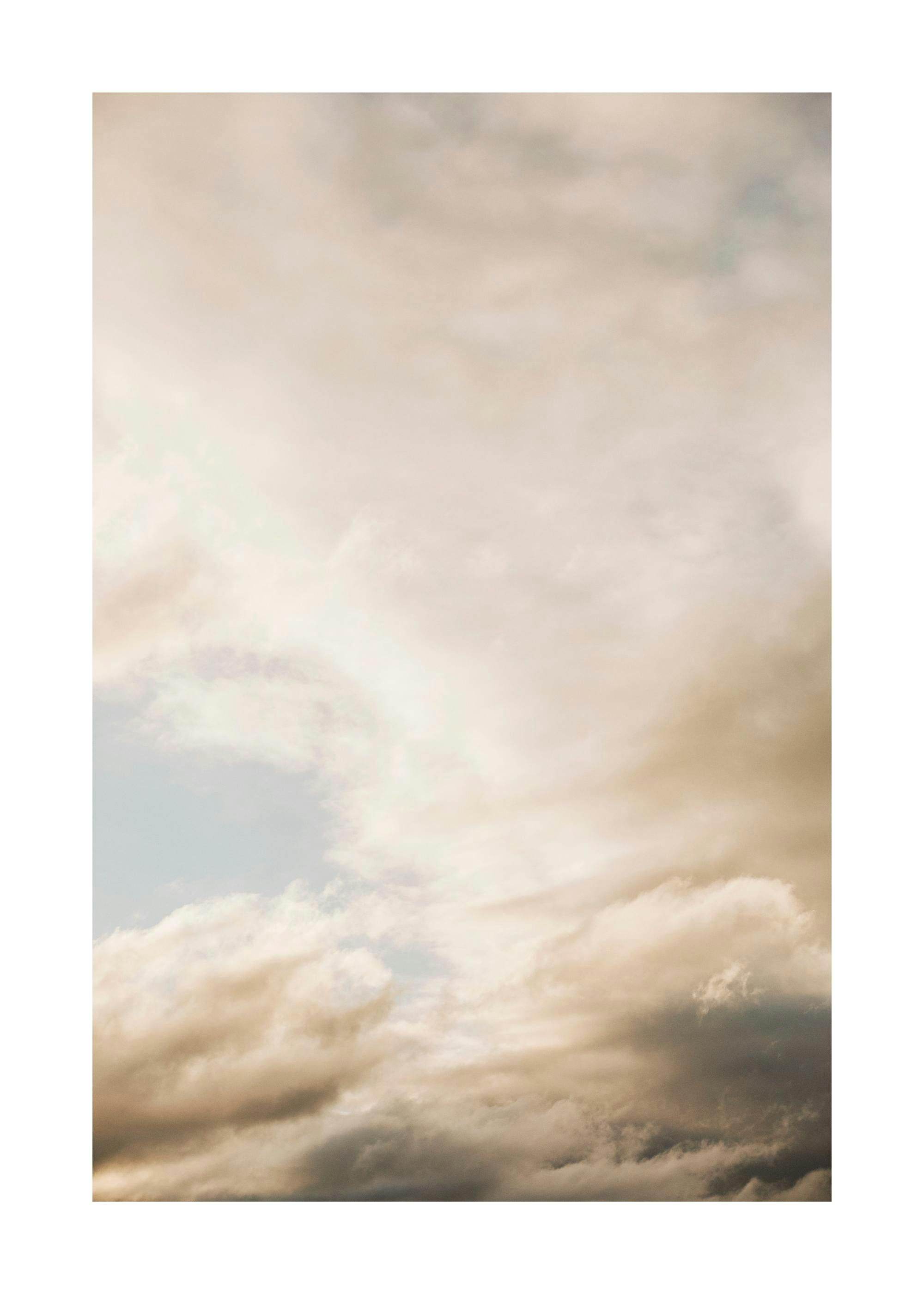 Affiche photo de nuages beiges et gris sur ciel bleu clair. Typographie douce et moderne pour une décoration légère.