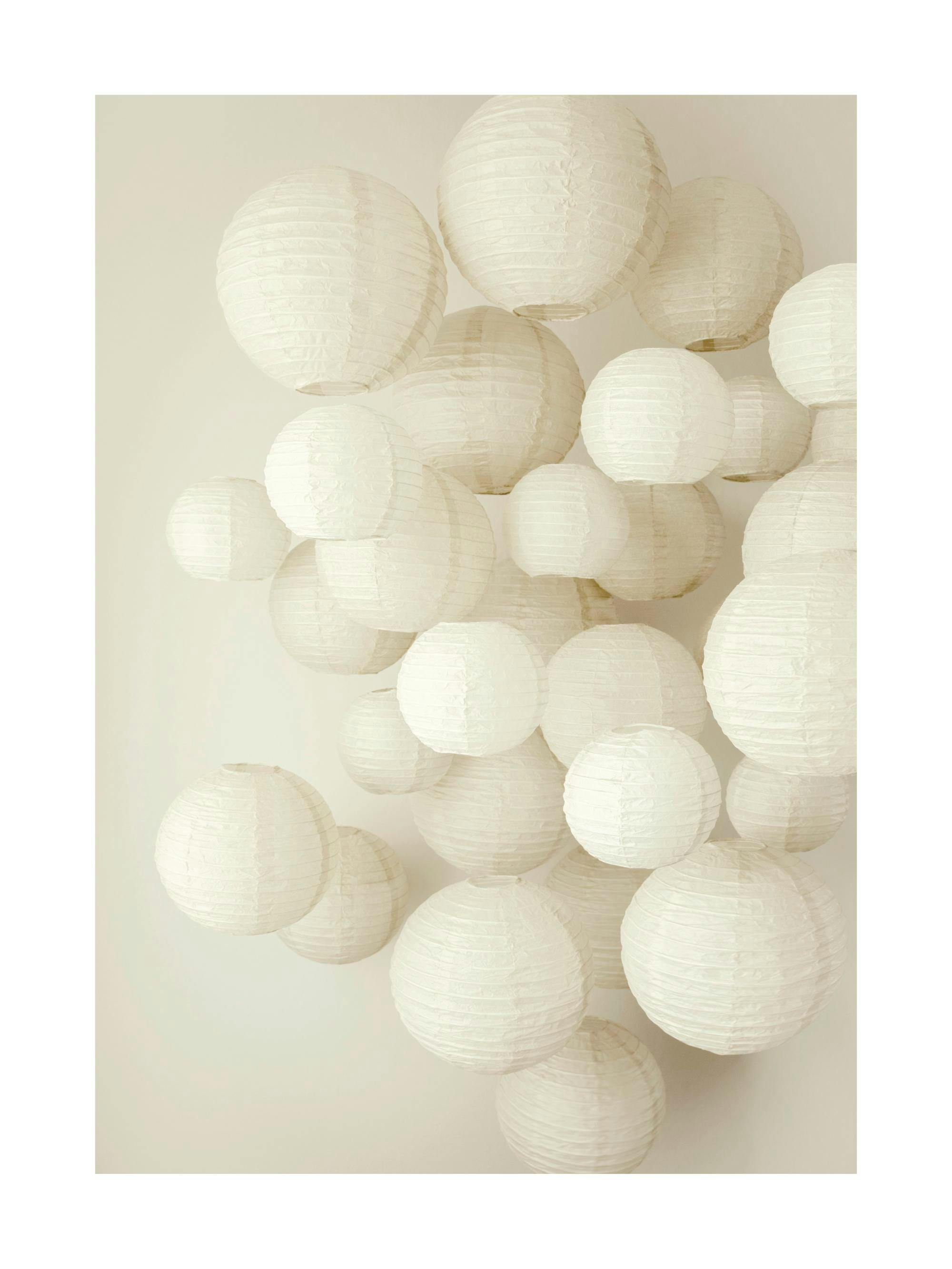 Fotografía de varios adornos redondos de papel de arroz blanco, creando un efecto de nube flotante.