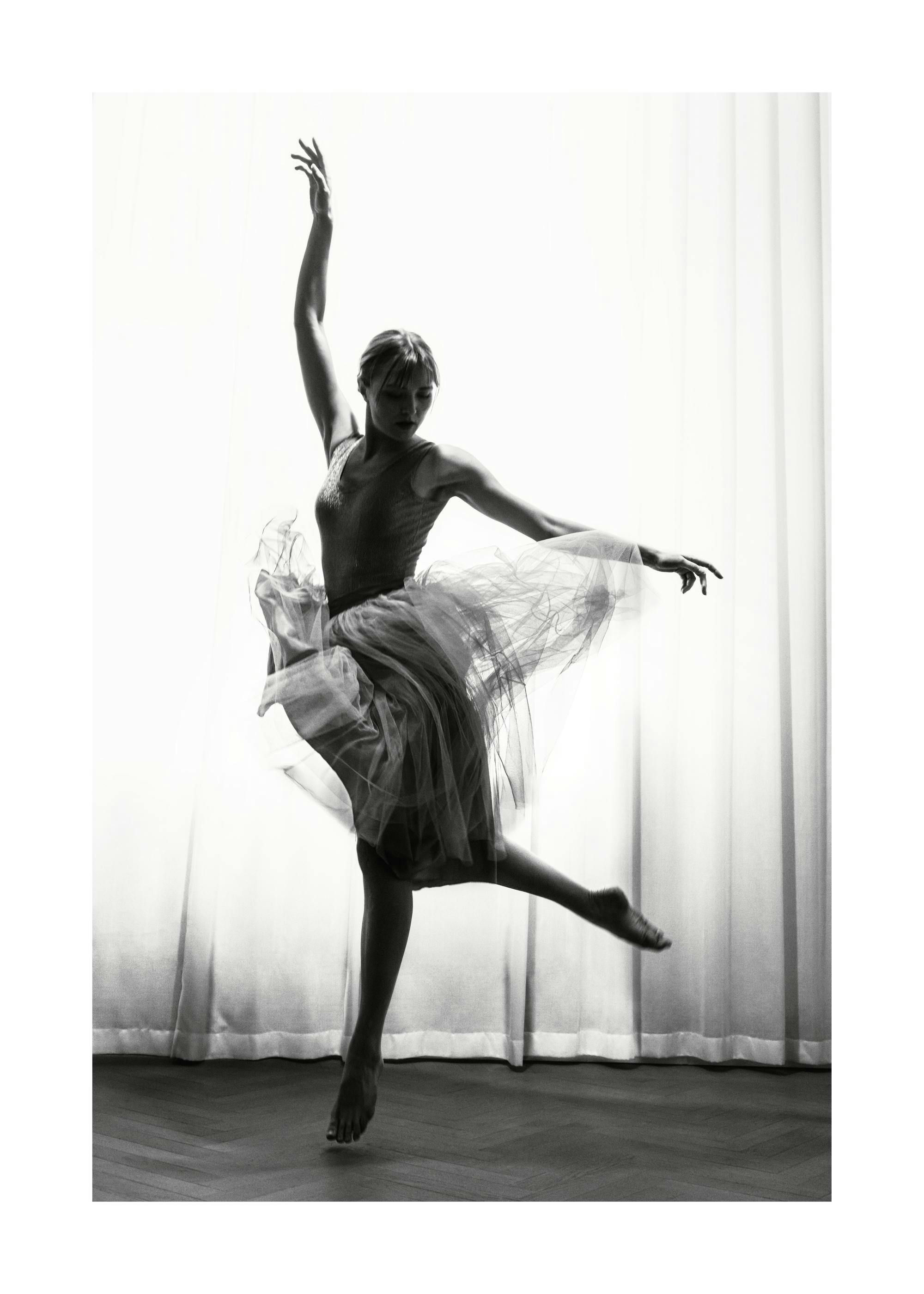 Póster de bailarina en movimiento, fotografía en blanco y negro con efecto borroso y granulado, falda de tul y pose elegante.
